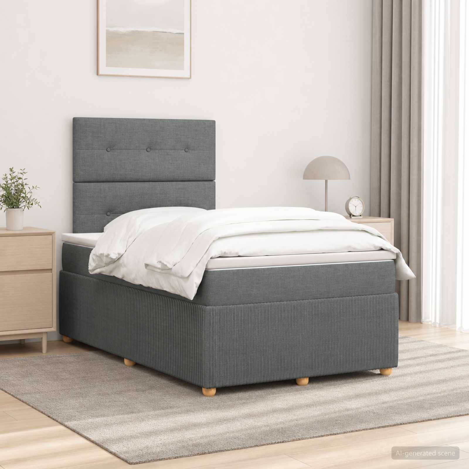 Grau gepolstertes Bett mit gestepptem Kopfteil mit Knopfheftung, weiße Bettwäsche und passende Schlafzimmermöbel in einem hellen, minimalistischen Zimmer.