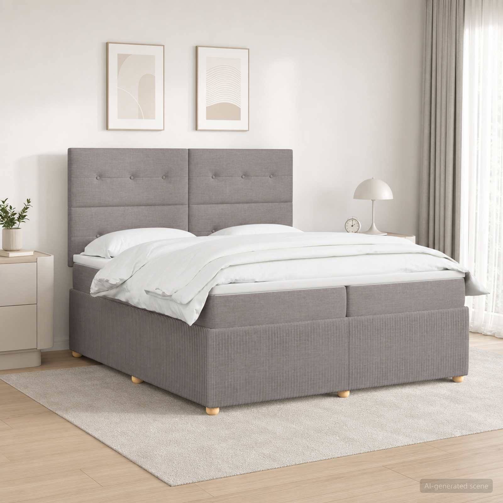 Modernes Schlafzimmer mit grauem gepolstertem Bett, weißer Bettwäsche, zwei gerahmten Drucken, Nachttisch, Lampe, Vorhang und hellem Teppich.