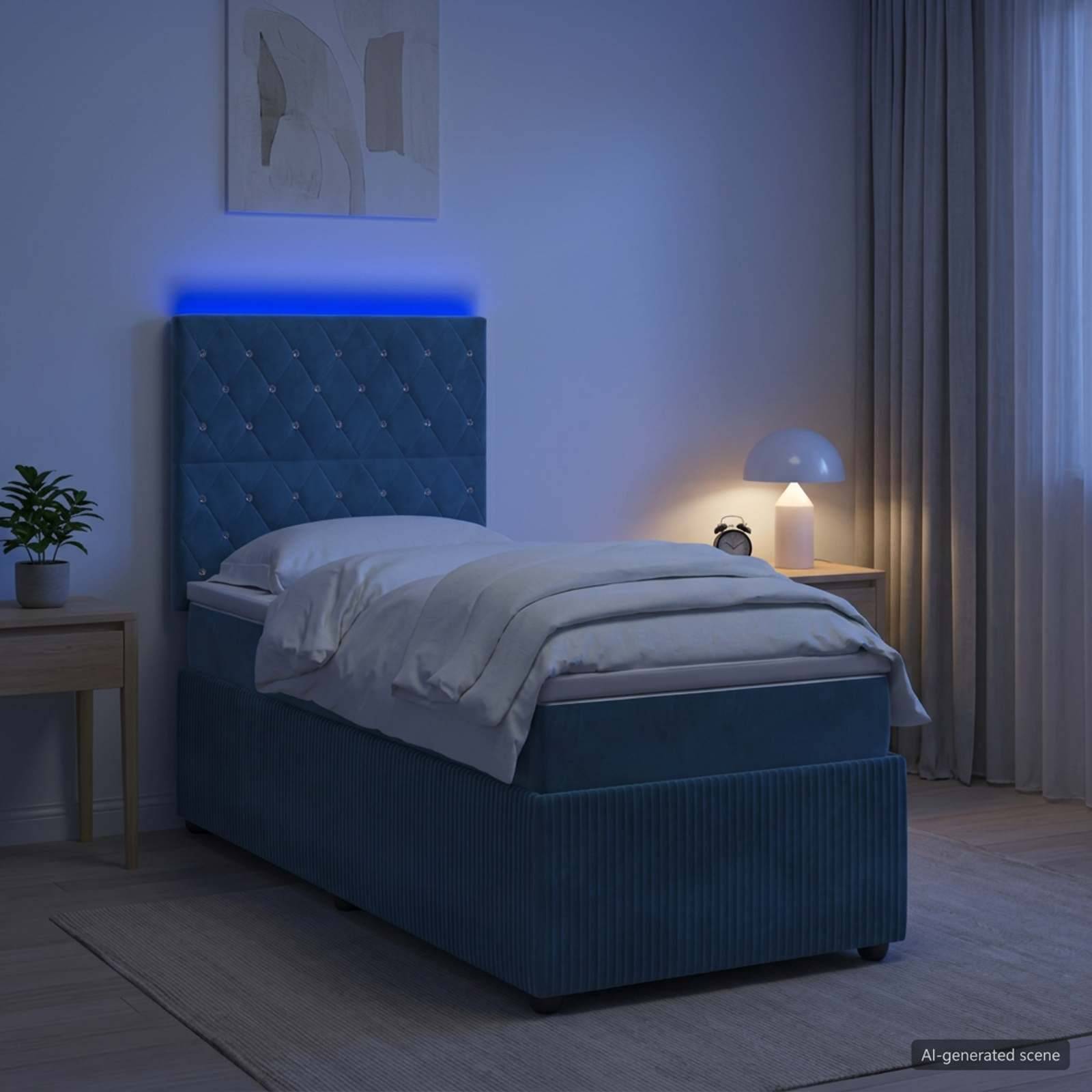 Ein modernes Schlafzimmer mit einem blau gepolsterten Bett, weißer Bettwäsche, einer Nachttischlampe, einer Pflanze und Vorhängen im sanften Abendlicht.