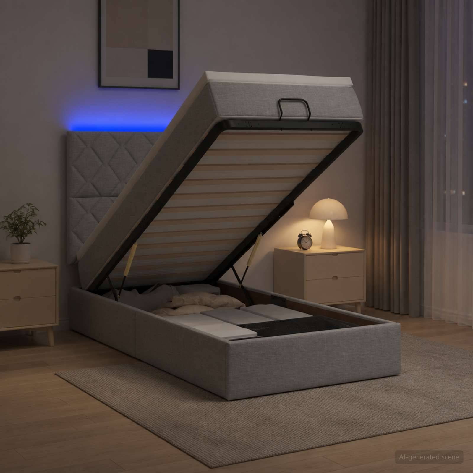 Grauer gepolsterter Bettrahmen mit Speicherlifttop, das angehoben und in einem sanft beleuchteten Schlafzimmer geöffnet ist, wobei die Matratzenunterlage und die inneren Stützlatten sichtbar sind.