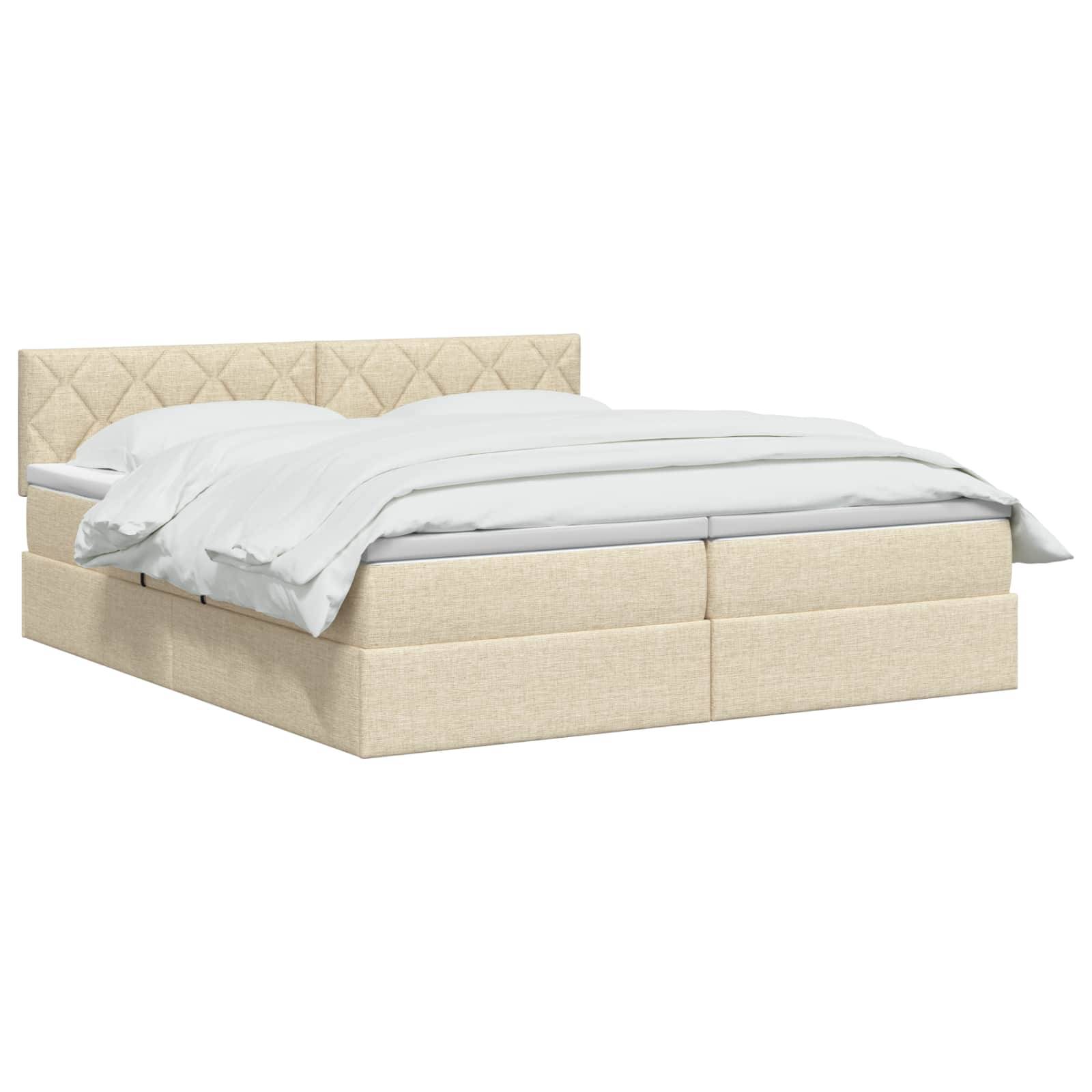 Beige gepolstertes Bett mit gestepptem Kopfteil und weißer Bettwäsche auf einfachem weißem Hintergrund.