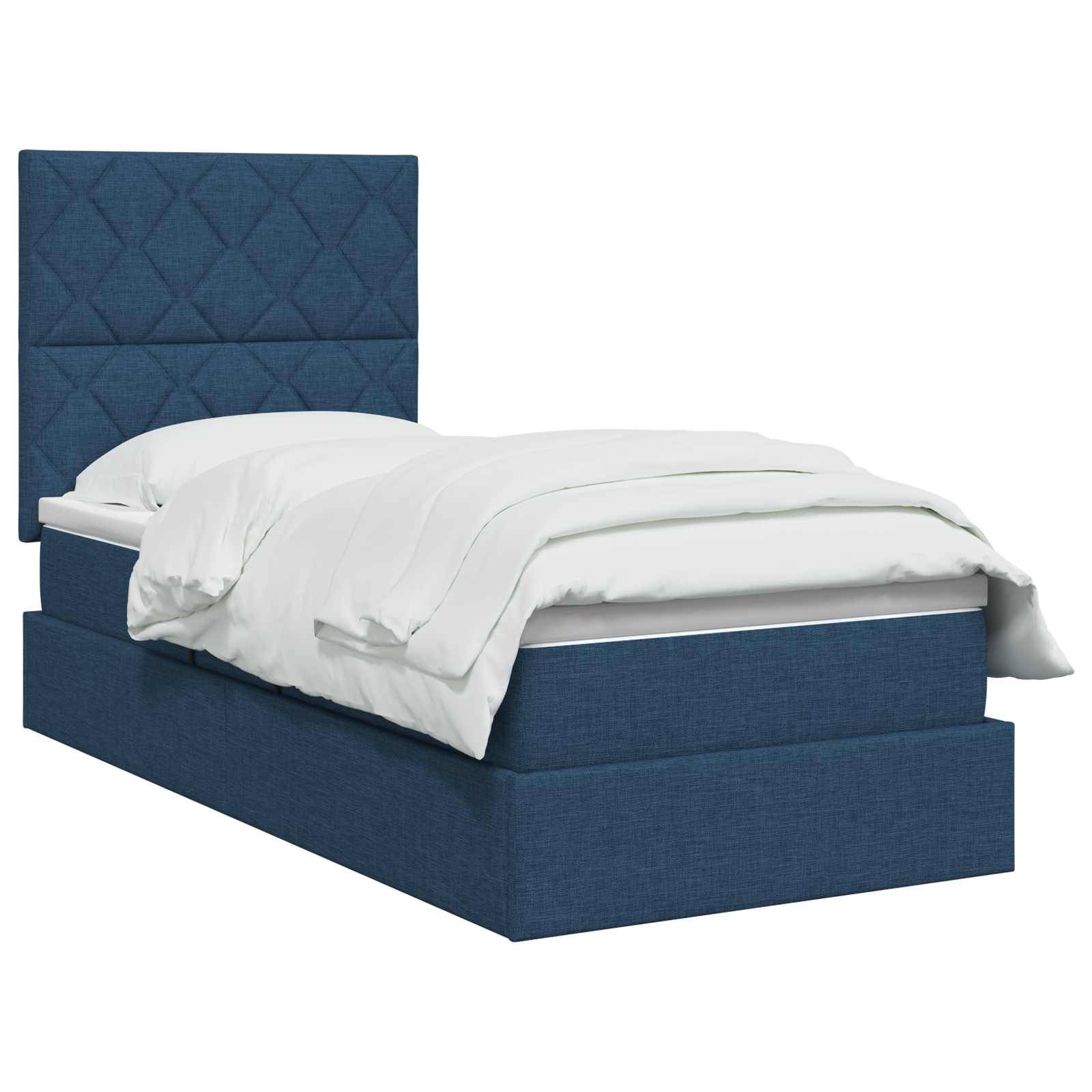 Bett mit blauem Polster und hohem gestepptem Kopfteil sowie weißer Bettwäsche auf einfachem weißem Hintergrund.