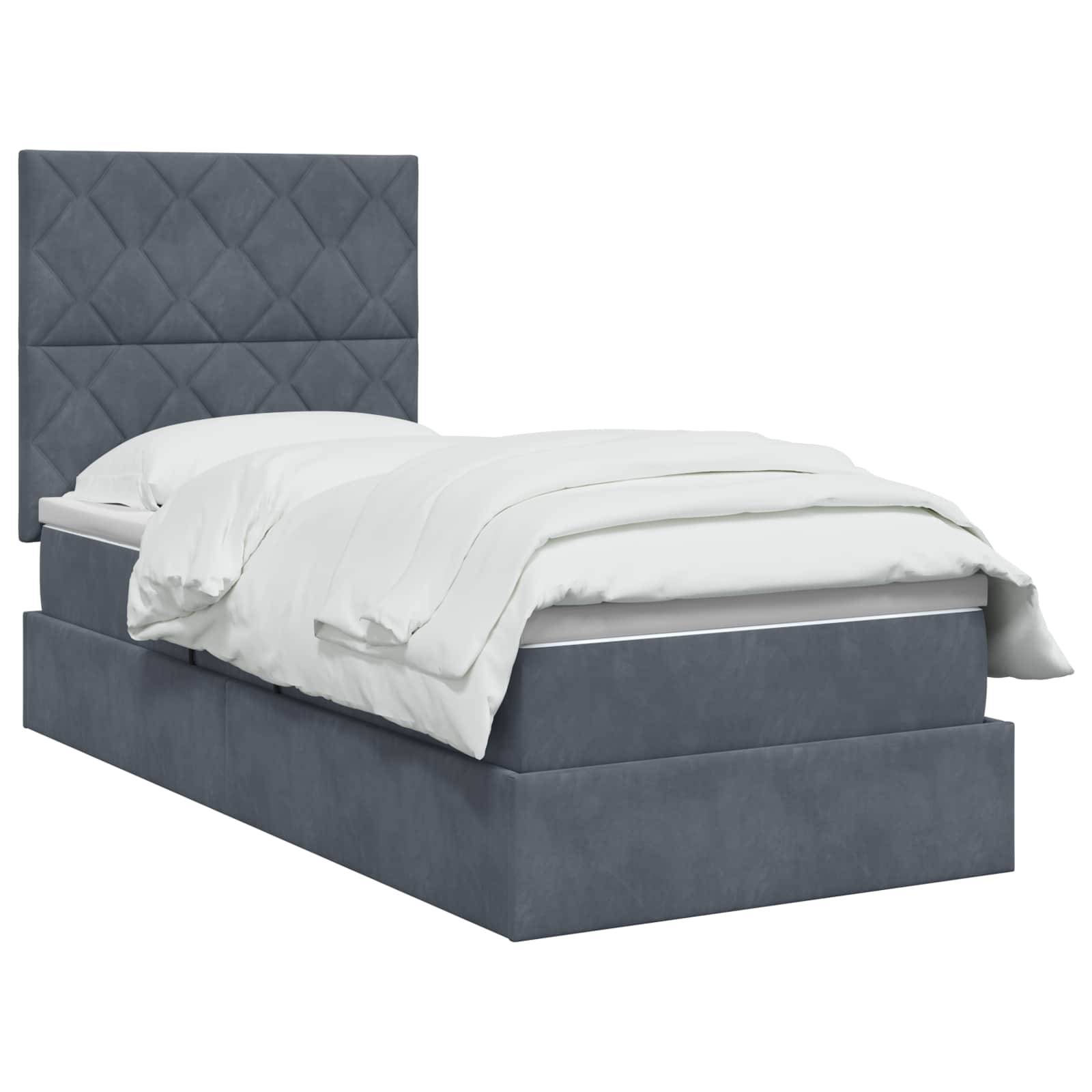 Grau gepolstertes Bett mit hohem gestepptem Kopfteil und weißer Bettwäsche auf einem Boxspringrahmen, vor weißem Hintergrund gezeigt.