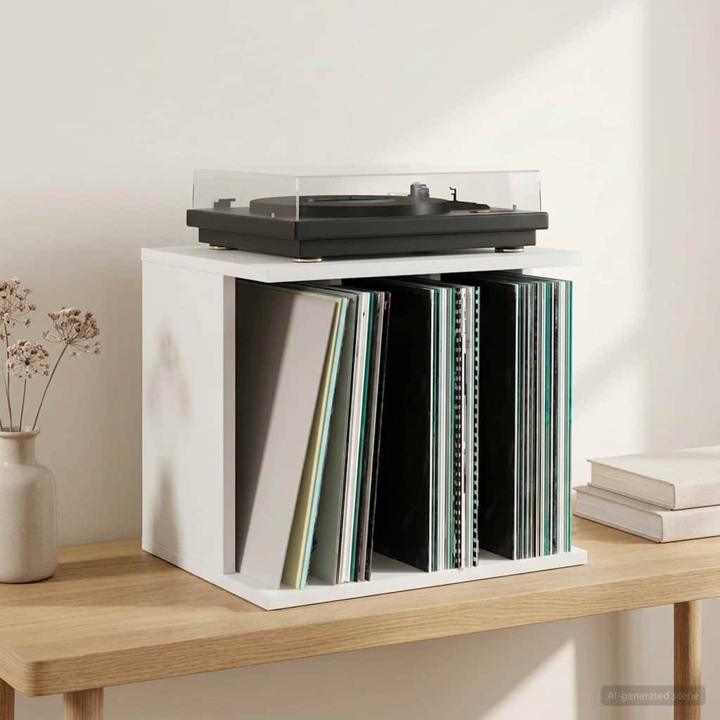 Plattenspieler auf einem weißen würfelförmigen Regal mit Schallplatten neben gestapelten Büchern auf einem Holztisch vor einer schlichten Wand.