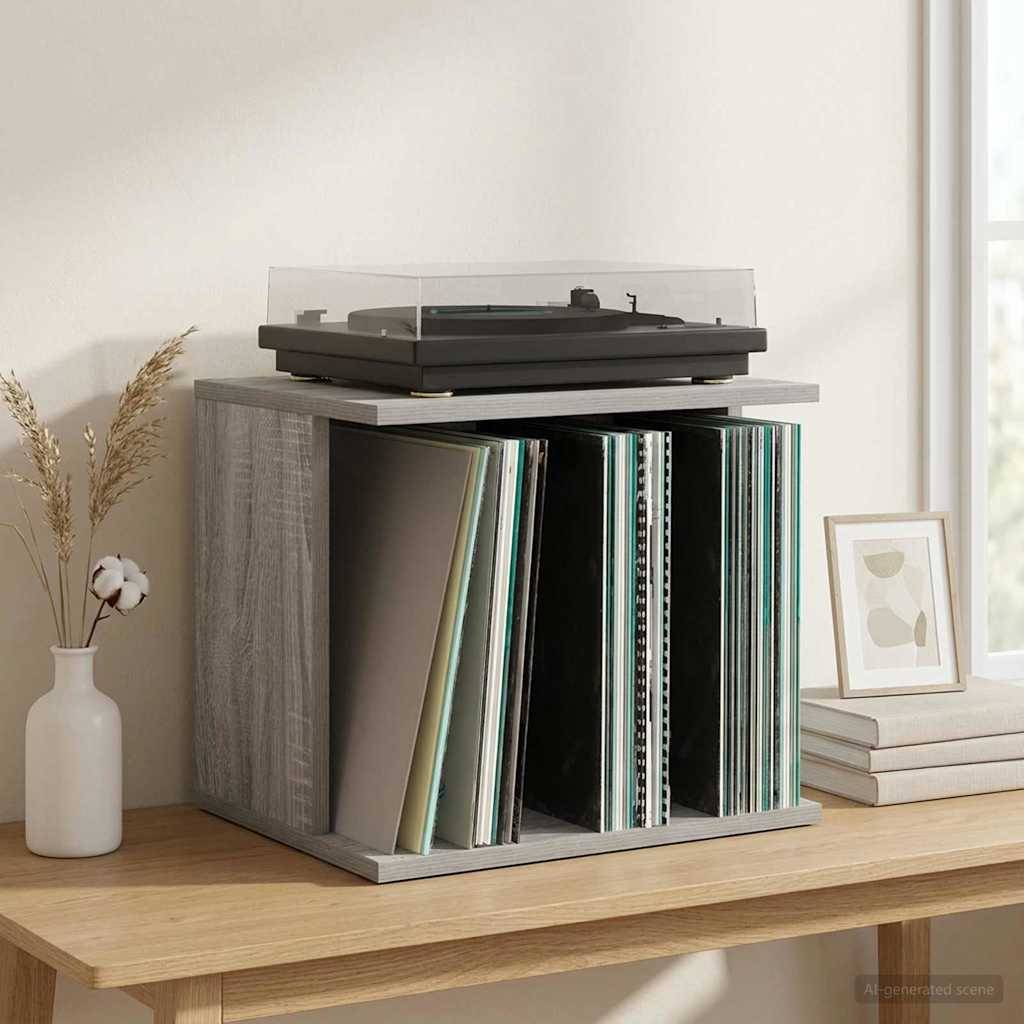 Plattenspieler auf einem grauen würfelförmigen Regal über Reihen von Schallplatten, neben einer weißen Vase und einem gerahmten Druck auf einem Holztisch neben einem Fenster.