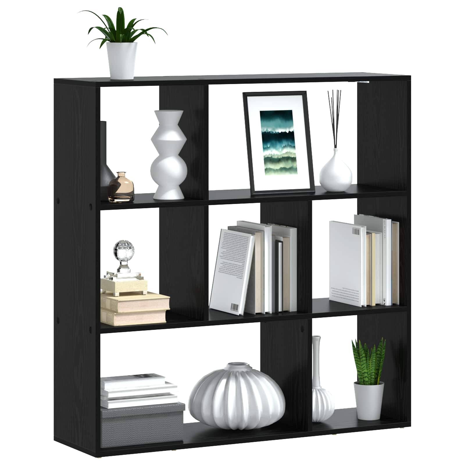 Schwarzes quadratisches Bücherregal mit sechs offenen Fächern, die Bücher, Rahmenkunst, Vasen, Pflanzen und dekorative Objekte auf weißem Hintergrund enthält.
