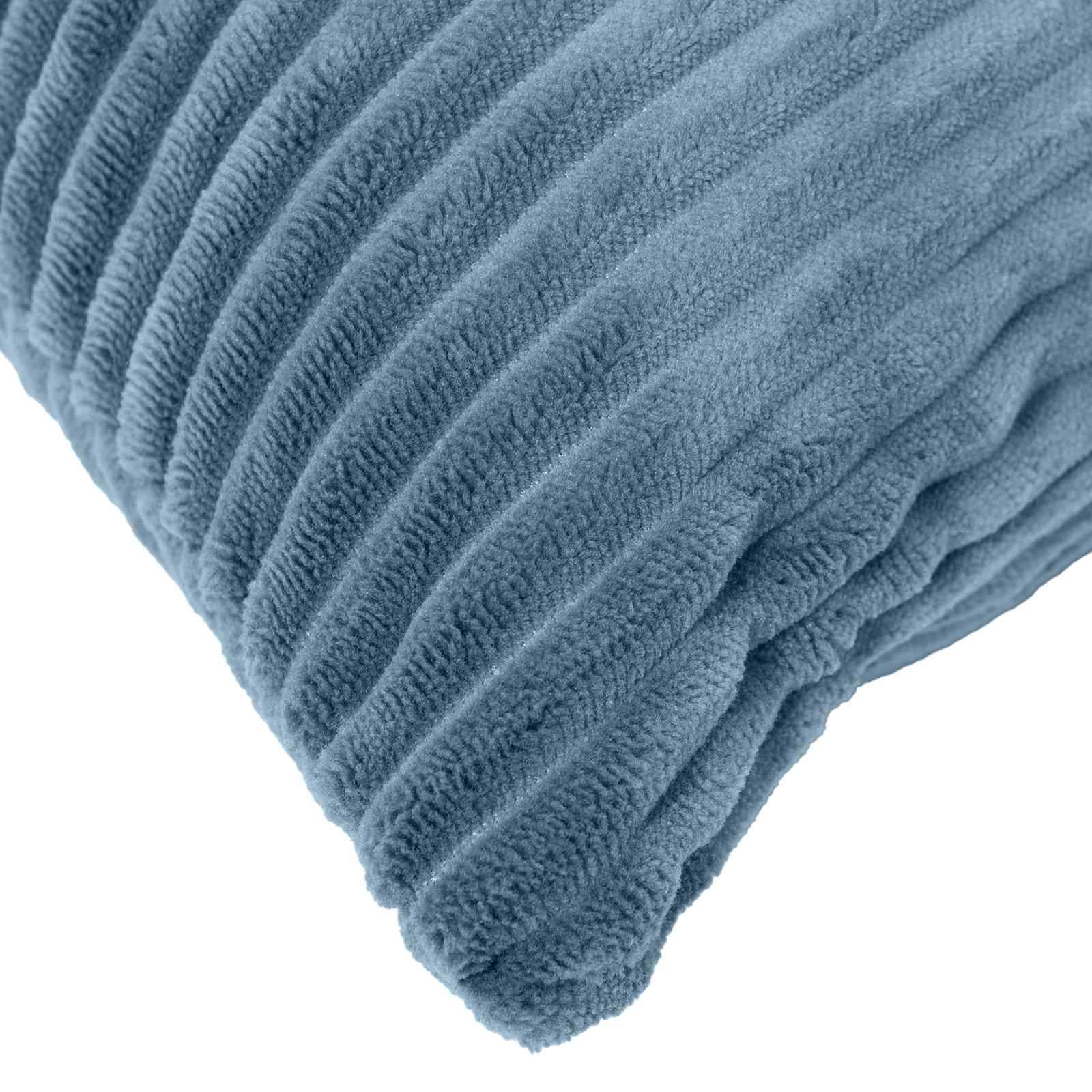 Nahaufnahme einer blauen strukturierten Decke oder Plüschstoff-Ecke, diagonal auf weißem Hintergrund gefaltet.
