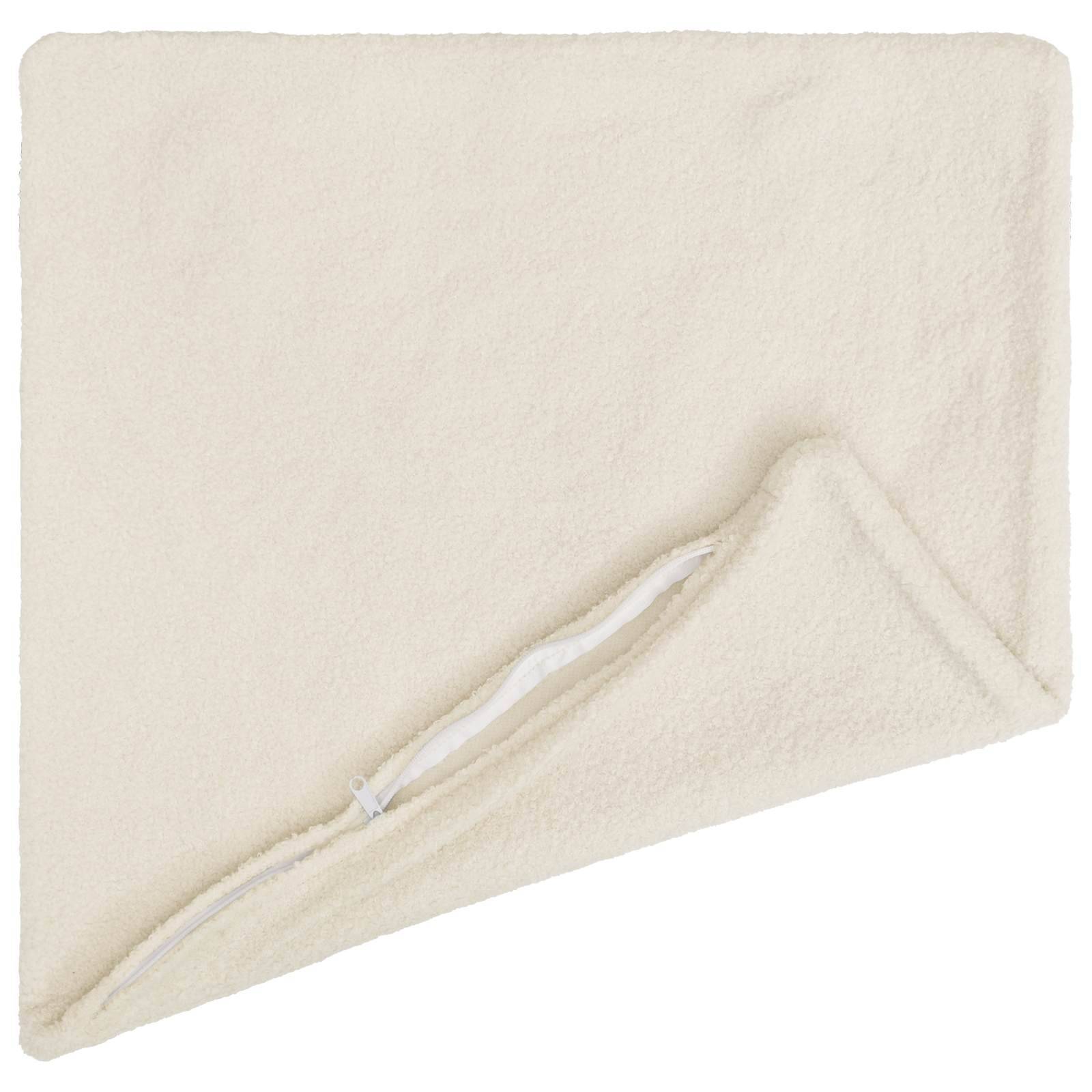 Creme­farbene Fleece-Decke diagonal gefaltet, mit einem weißen Reißverschluss entlang einer Kante.