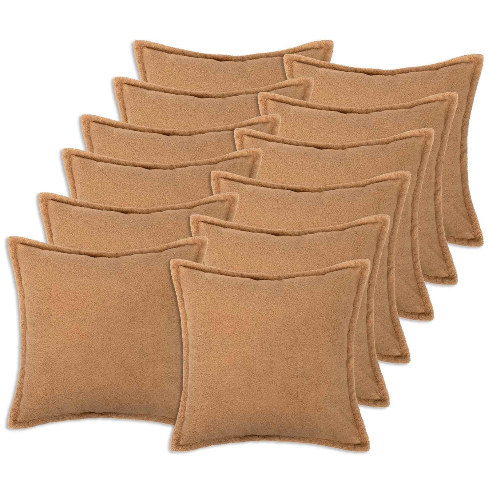 Stapel von acht beigen quadratischen Wurfkissen mit abgerundeten Ecken und gestickter Kante auf weißem Hintergrund.