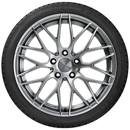 Nahaufnahme eines schwarzen Autoreifen mit einer glänzenden silbernen Leichtmetallfelge mit mehreren Speichen auf dunklem Hintergrund.
