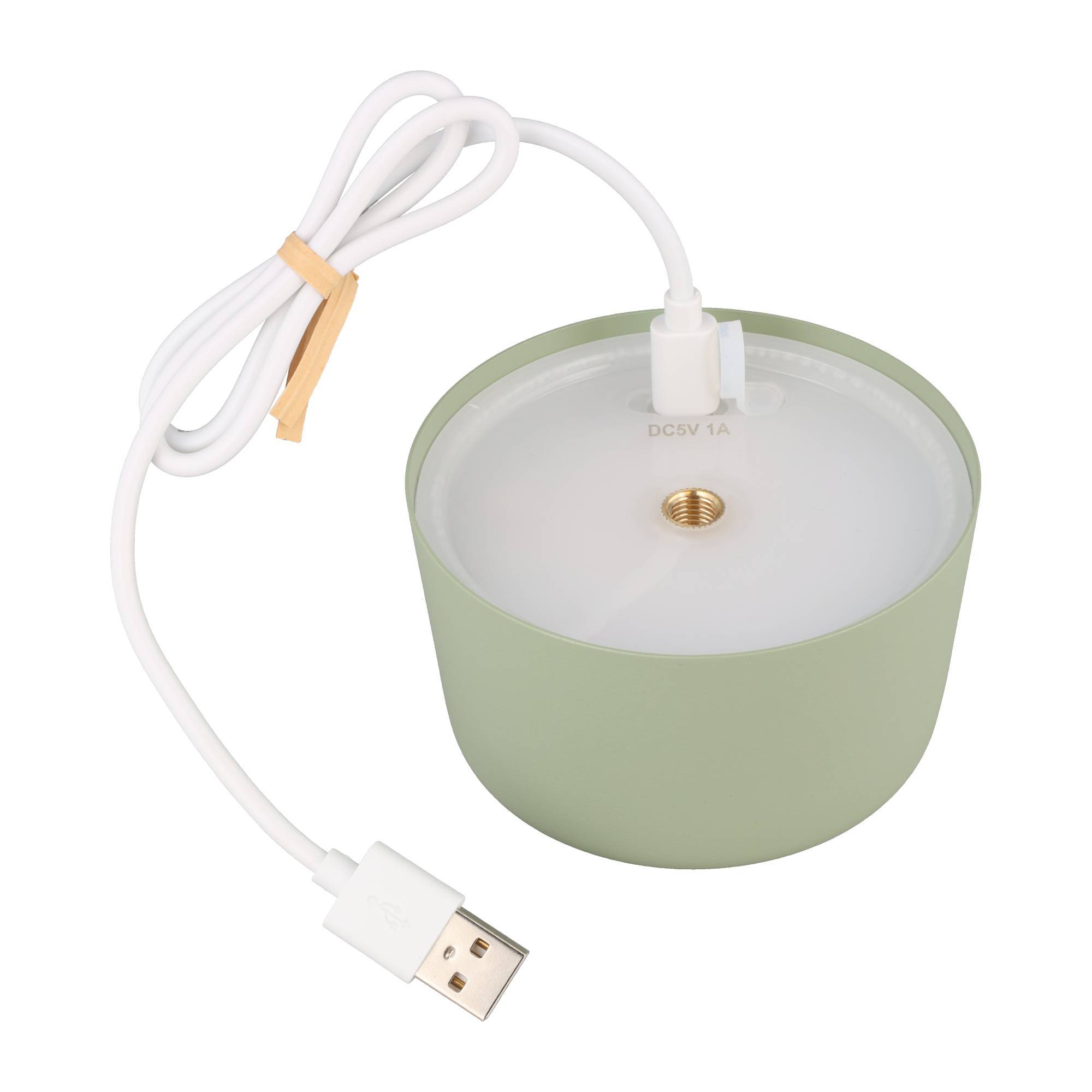 Kleines grünes zylindrisches Gerät mit weißem Deckel, Messingmittelstück und angeschlossenem weißem USB-Kabel mit der Beschriftung DC5V 1A.