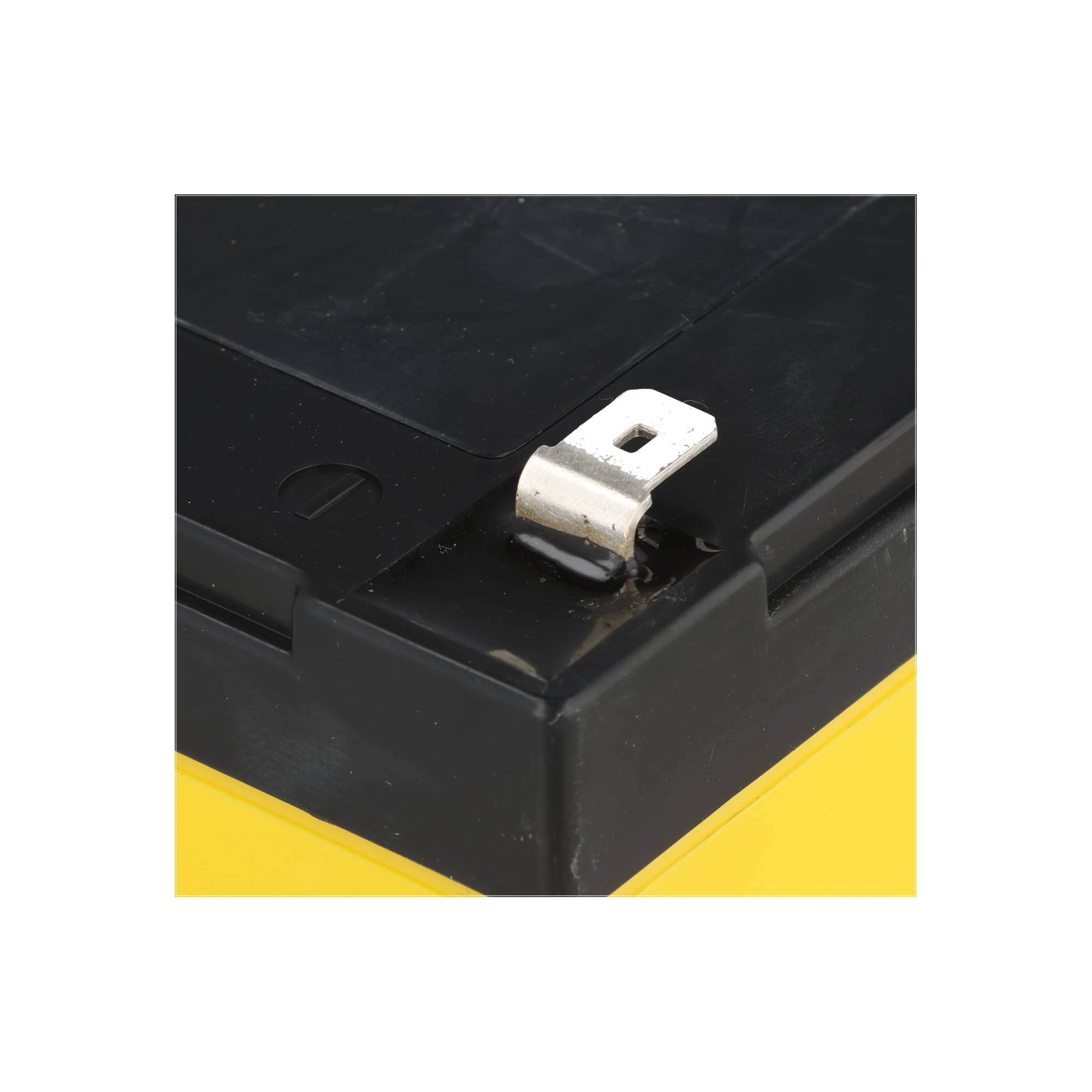 Nahaufnahme einer schwarzen Batterie oder eines Geräts mit einer weißen Metallklemme/einem Stecker, der von oben herausragt.