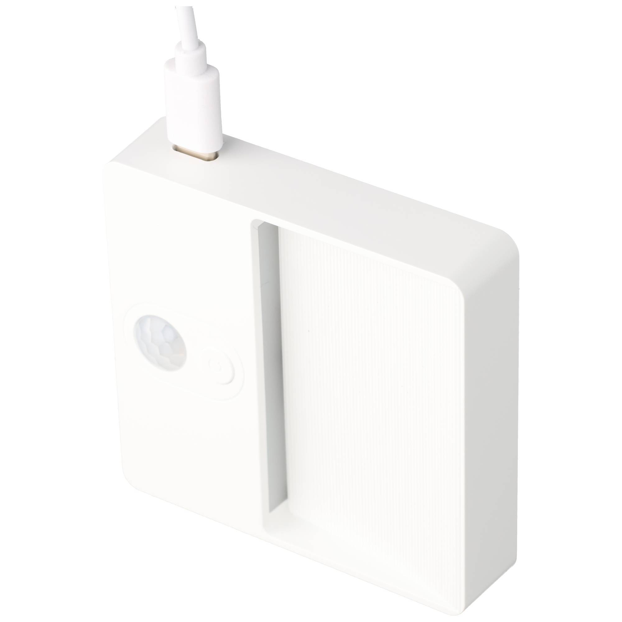 Weißes wandmontiertes Gerät mit einem Kabel, das oben eingesteckt ist, und einem runden Sensor oder Knopf an der Vorderseite.
