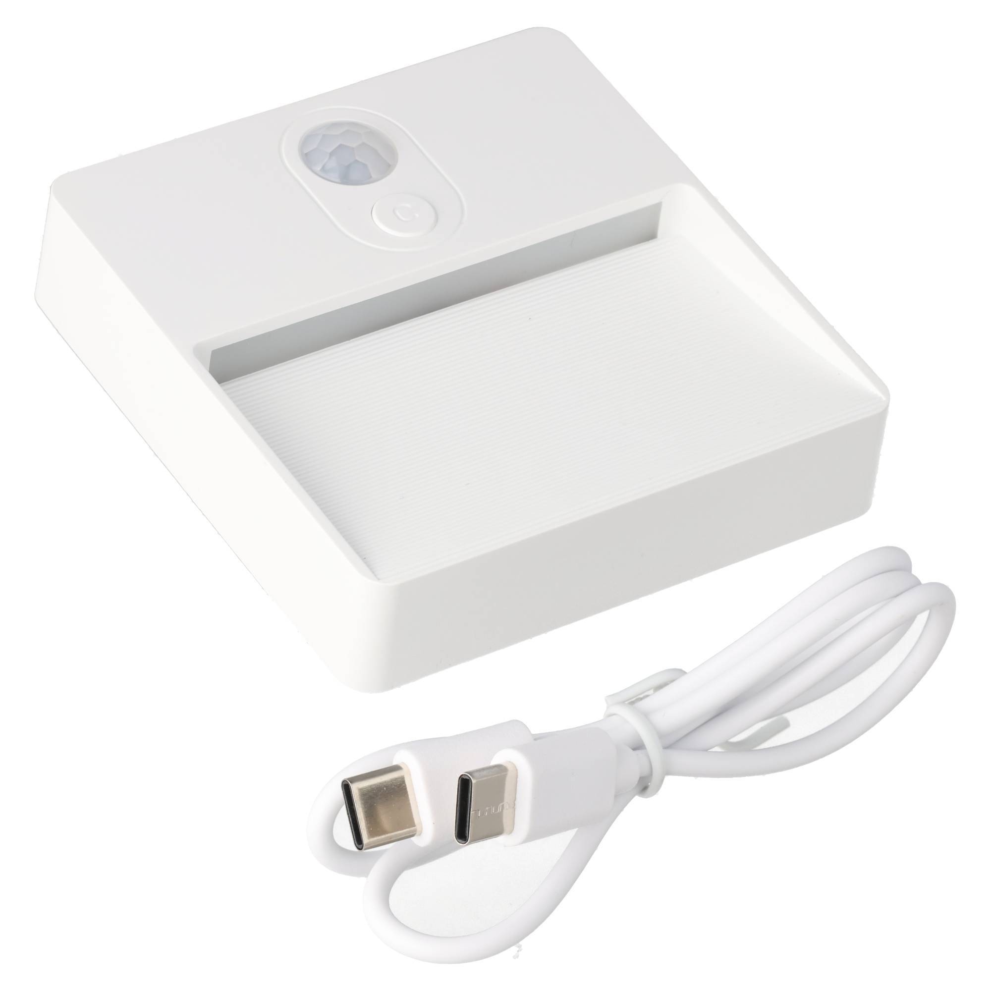 Weiße quadratische Bewegungsmelderleuchte mit integriertem LED-Panel und angeschlossenem weißem USB-Ladekabel auf neutralem Hintergrund.