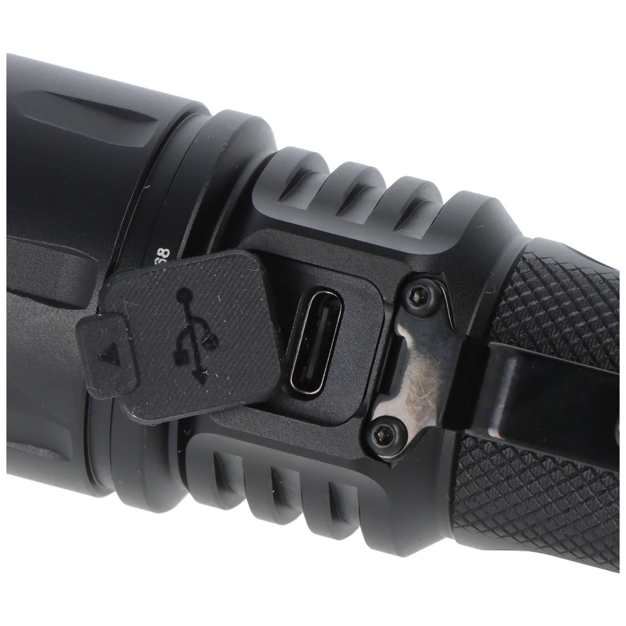 Nahaufnahme einer Taschenlampe oder eines Geräts mit einem USB-C-Ladeanschluss, der durch eine Gummilasche neben einem strukturierten Griff abgedeckt ist.