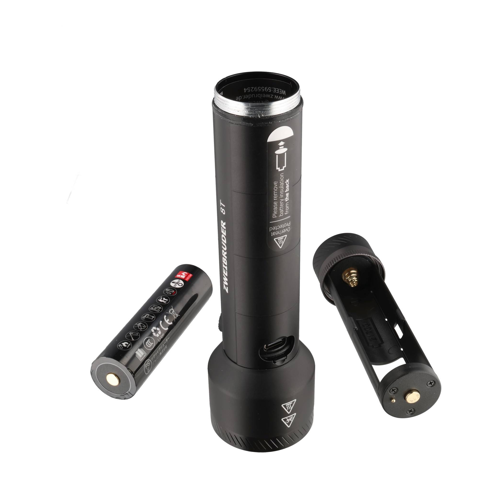 Schwarze zylindrische Taschenlampe mit entferntem Batterieträger und entfernter Endkappe, auf weißem Hintergrund abgebildet, um interne Teile anzuzeigen.