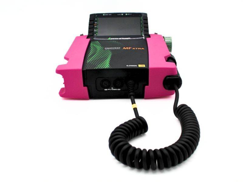 Tragbares elektronisches Gerät in Schwarz und Rosa mit kleinem Bildschirm und angebrachten Spiralkabeln, auf weißem Hintergrund gezeigt.