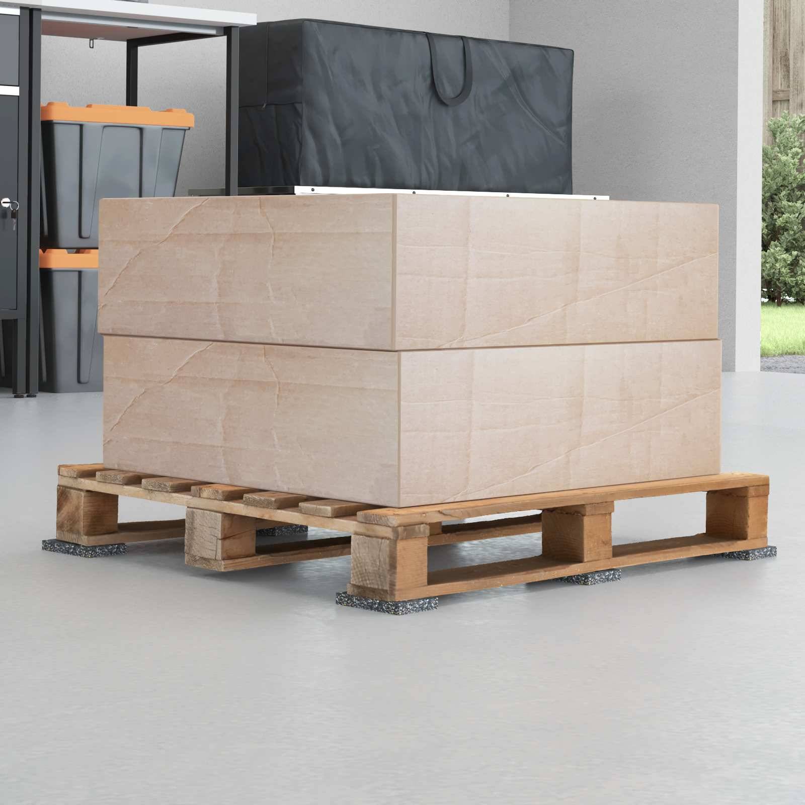 Zwei große Kartonboxen, übereinander gestapelt auf einer Holzpalette in einem lagerhausähnlichen Raum.