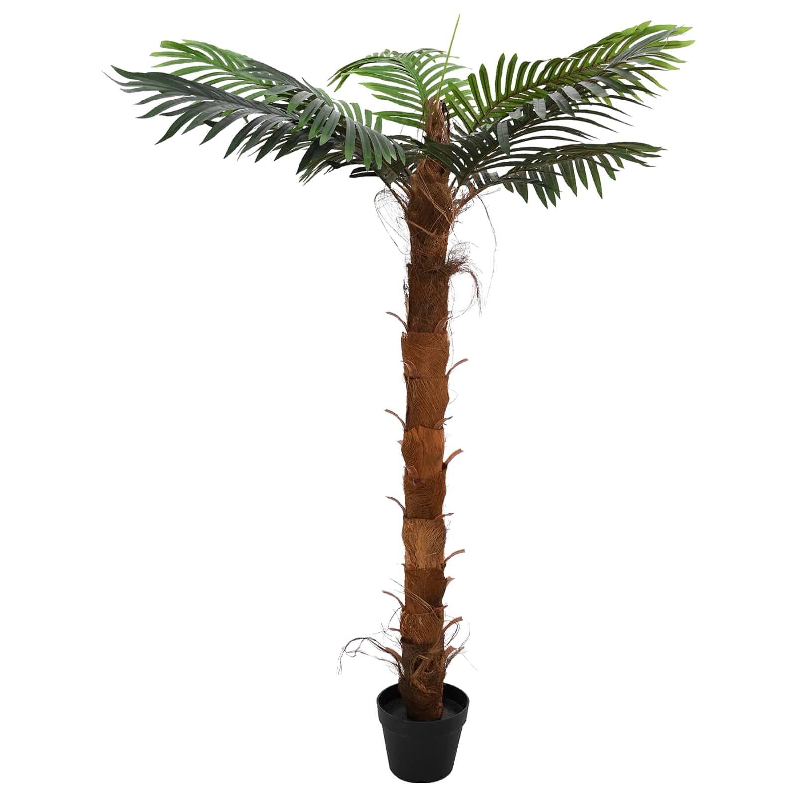 Künstliche Palme im Topf mit hohem braunem Stamm und grünen Palmwedeln vor einfachem weißem Hintergrund.