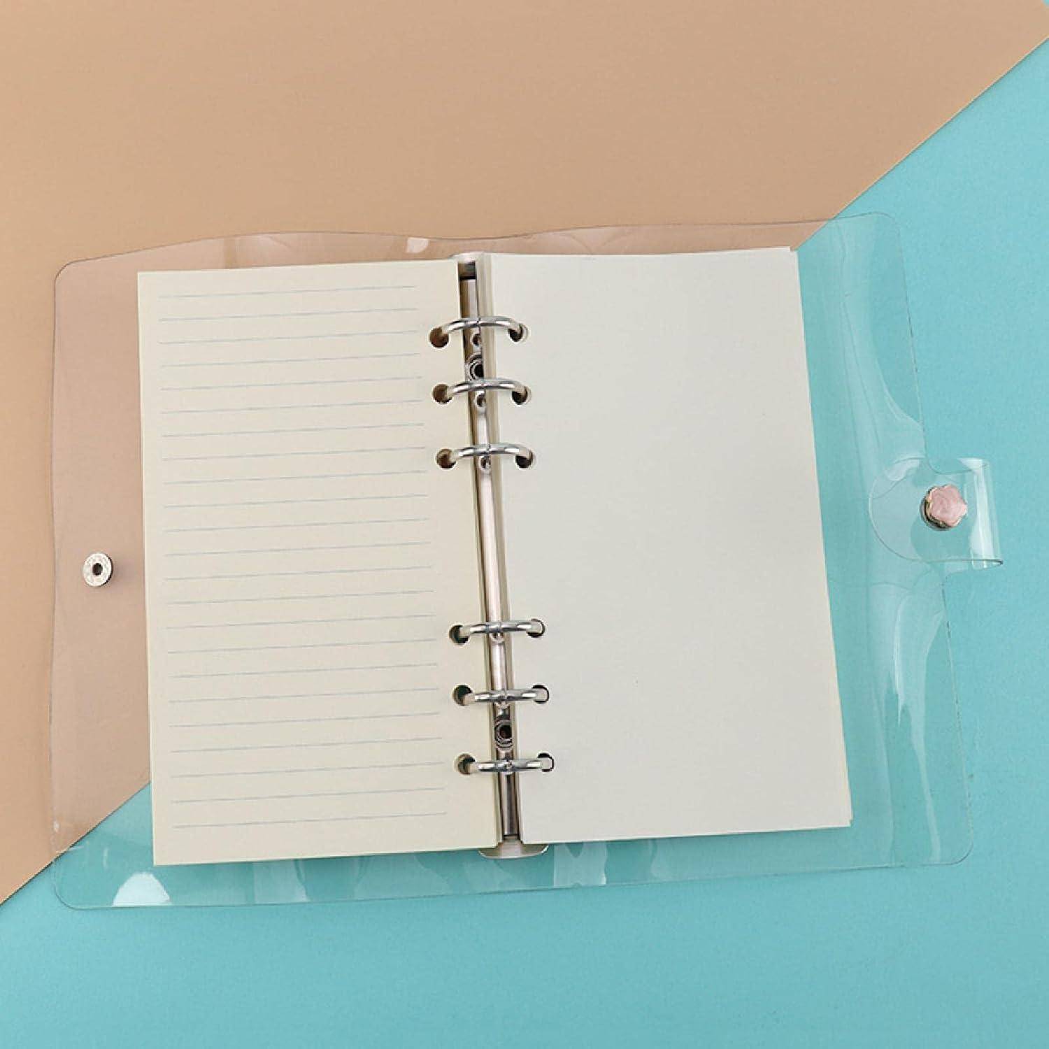 Offenes blanko Ringbuch-Notizbuch in einer durchscheinenden rosa und türkisen Kunststoffmappe auf einer blauen Oberfläche.