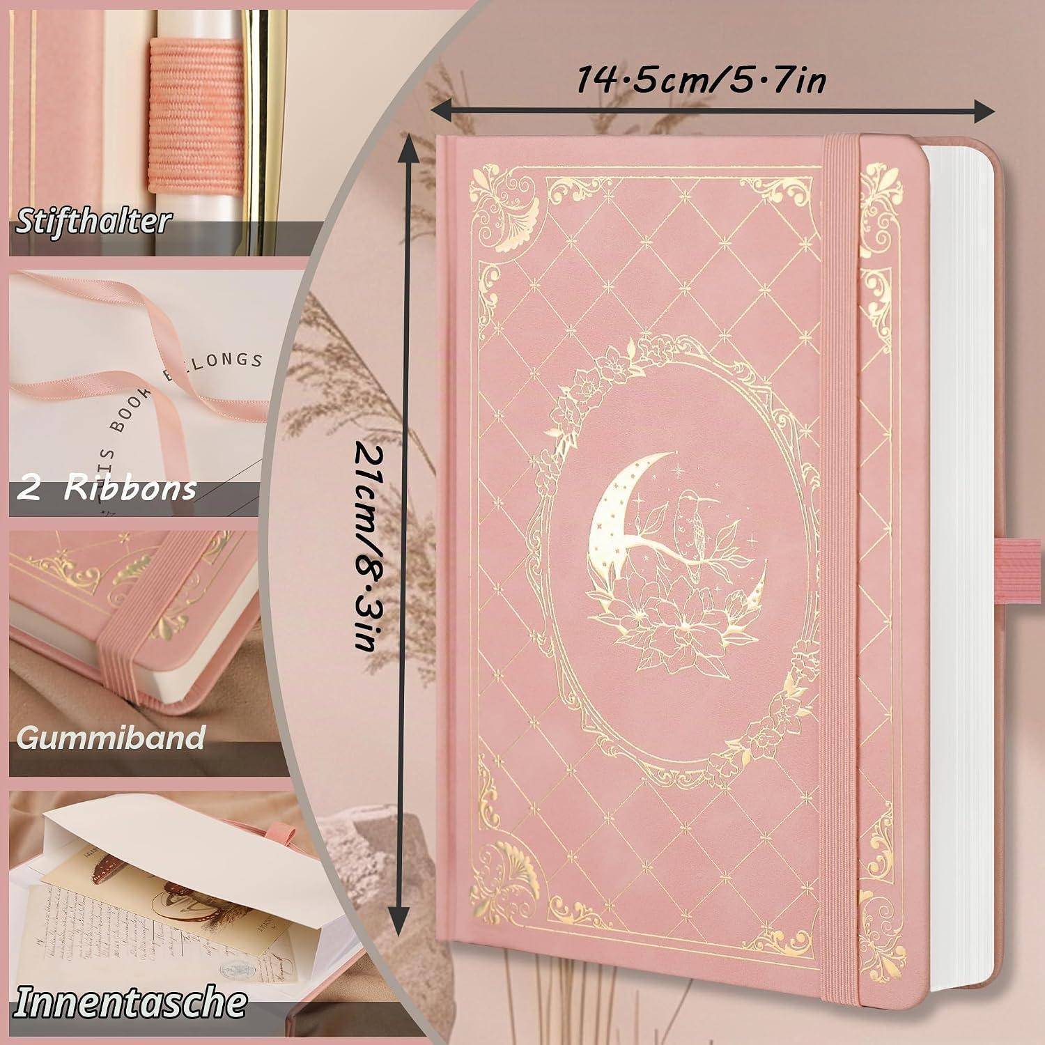 Rosa Hardcover-Notizbuch mit goldenem Halbmondentwurf, Gummiband, Lesezeichen mit Bändern und innerer Tasche; beschriftet 14,5 cm x 21 cm.