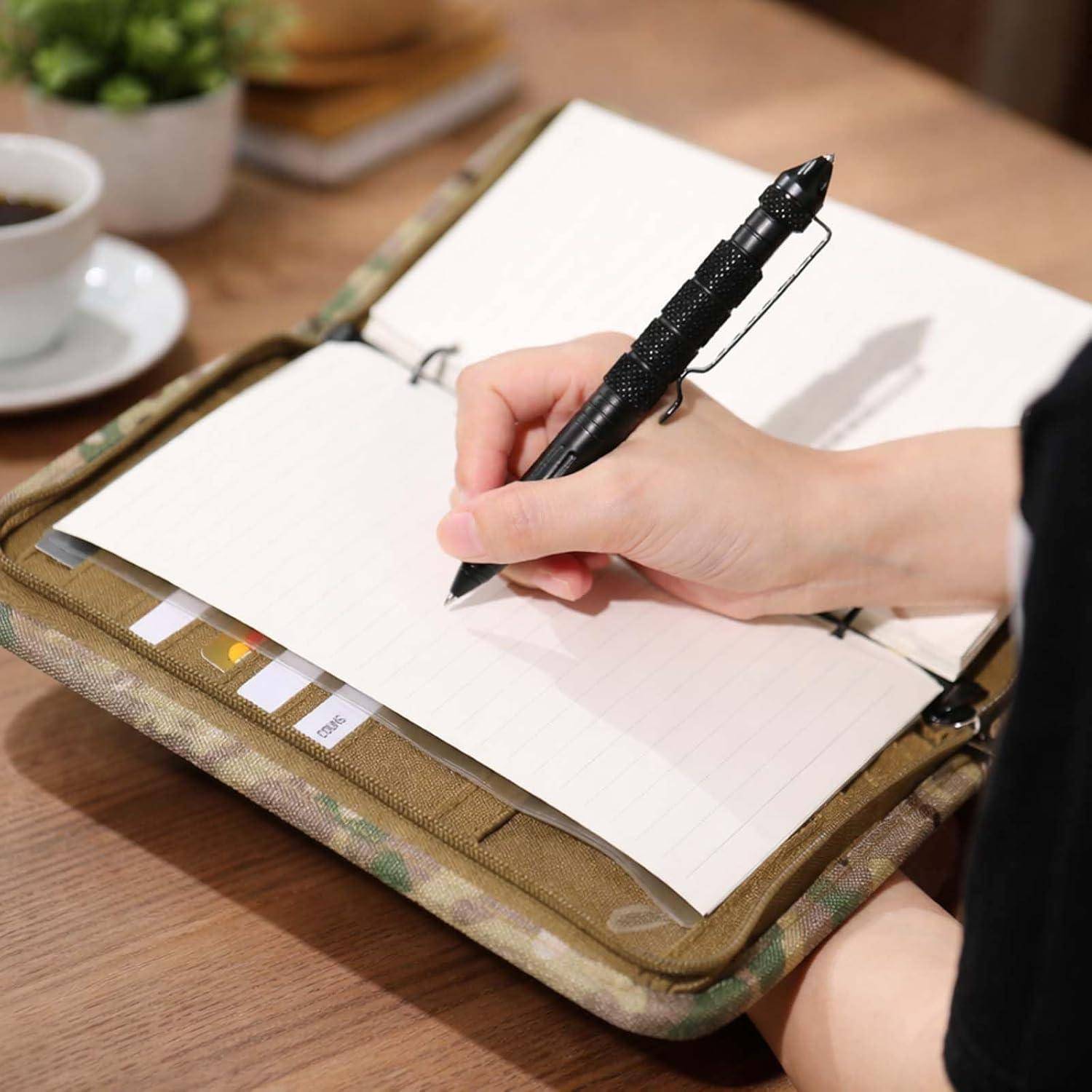 Handschrift in einem offenen Notizbuch mit Linien und einem schwarzen Stift auf einem Tisch, was auf Notizen machen oder Journalschreiben hindeutet.