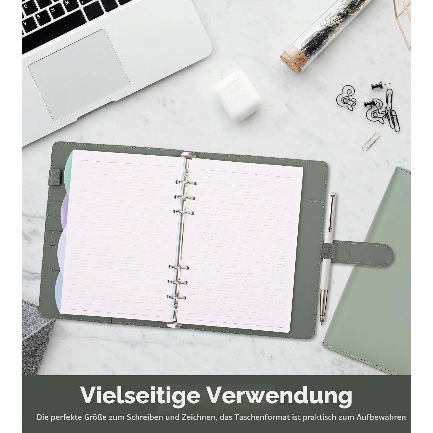 Offene Ringnotizplaner auf einem Schreibtisch mit Stift, Laptop, Büroklammern und Textbanner 