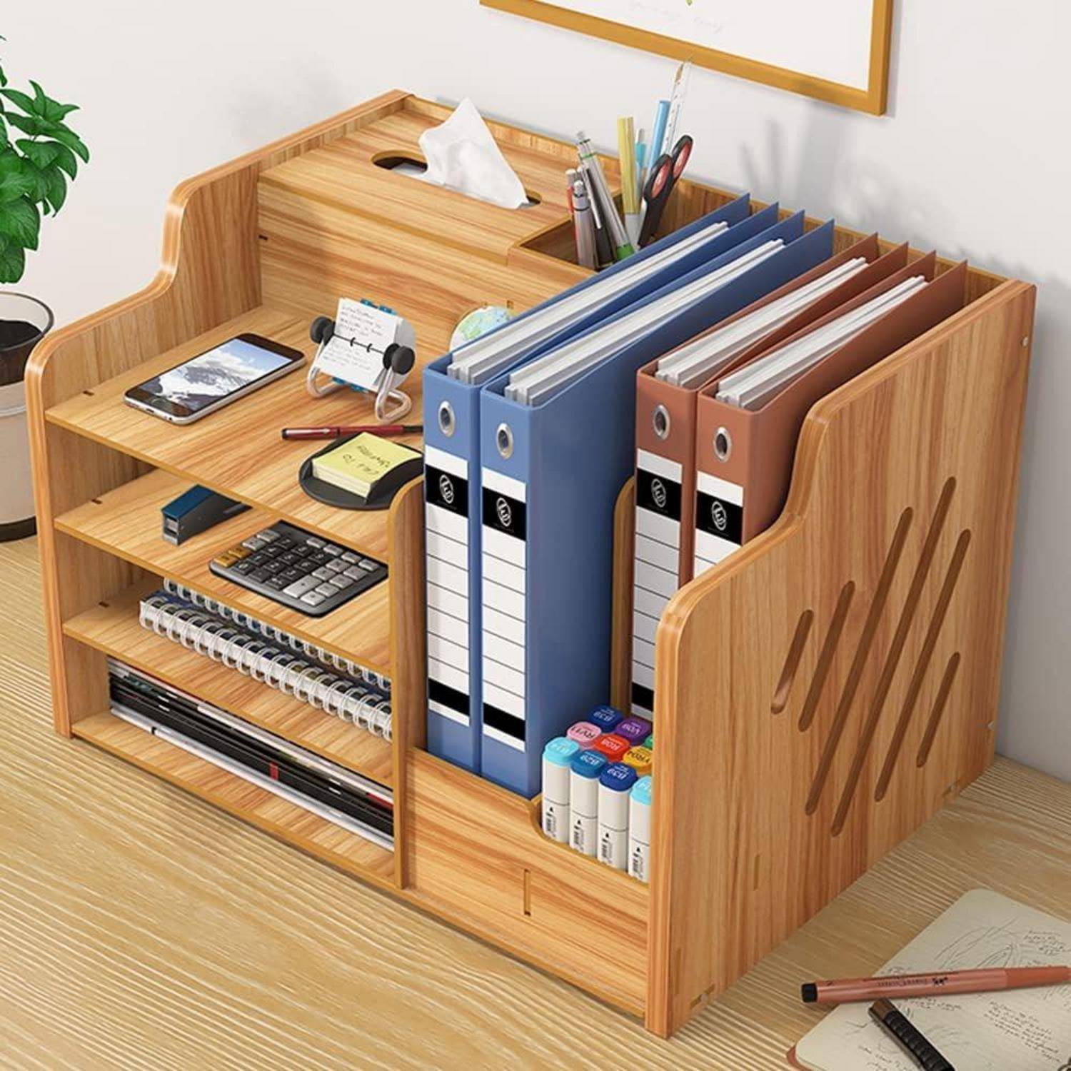 Holzschreibtischorganizer mit Ordnern, Stiften, Taschenrechner, Telefon, Haftnotizen, Notizbüchern und Markern auf Regalen für die Bürospeicherung angeordnet.