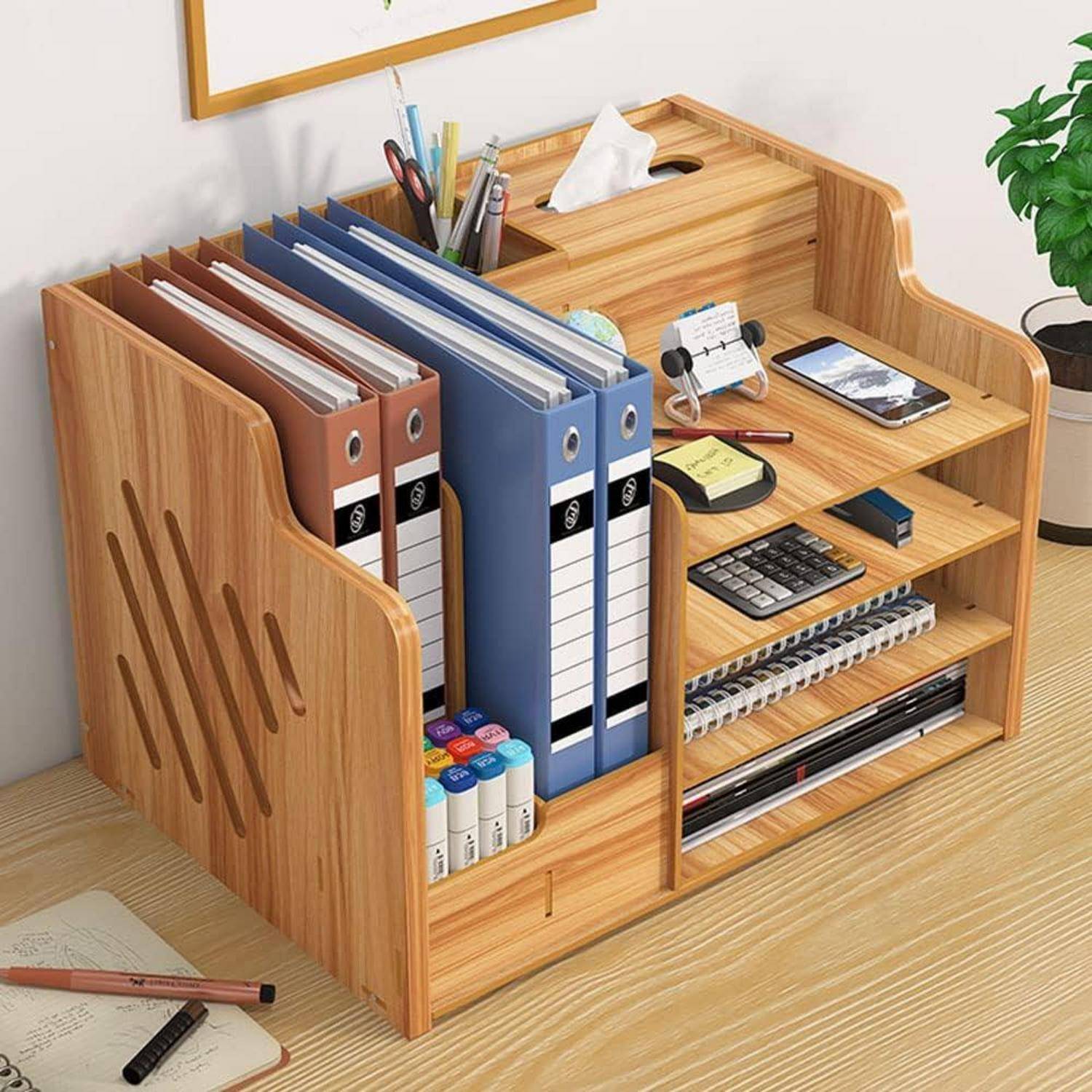 Holzschreibtisch-Organizer mit Aktenmappen, Stiften, Taschenrechner, Telefon und Notizbüchern auf einem Schreibtisch.