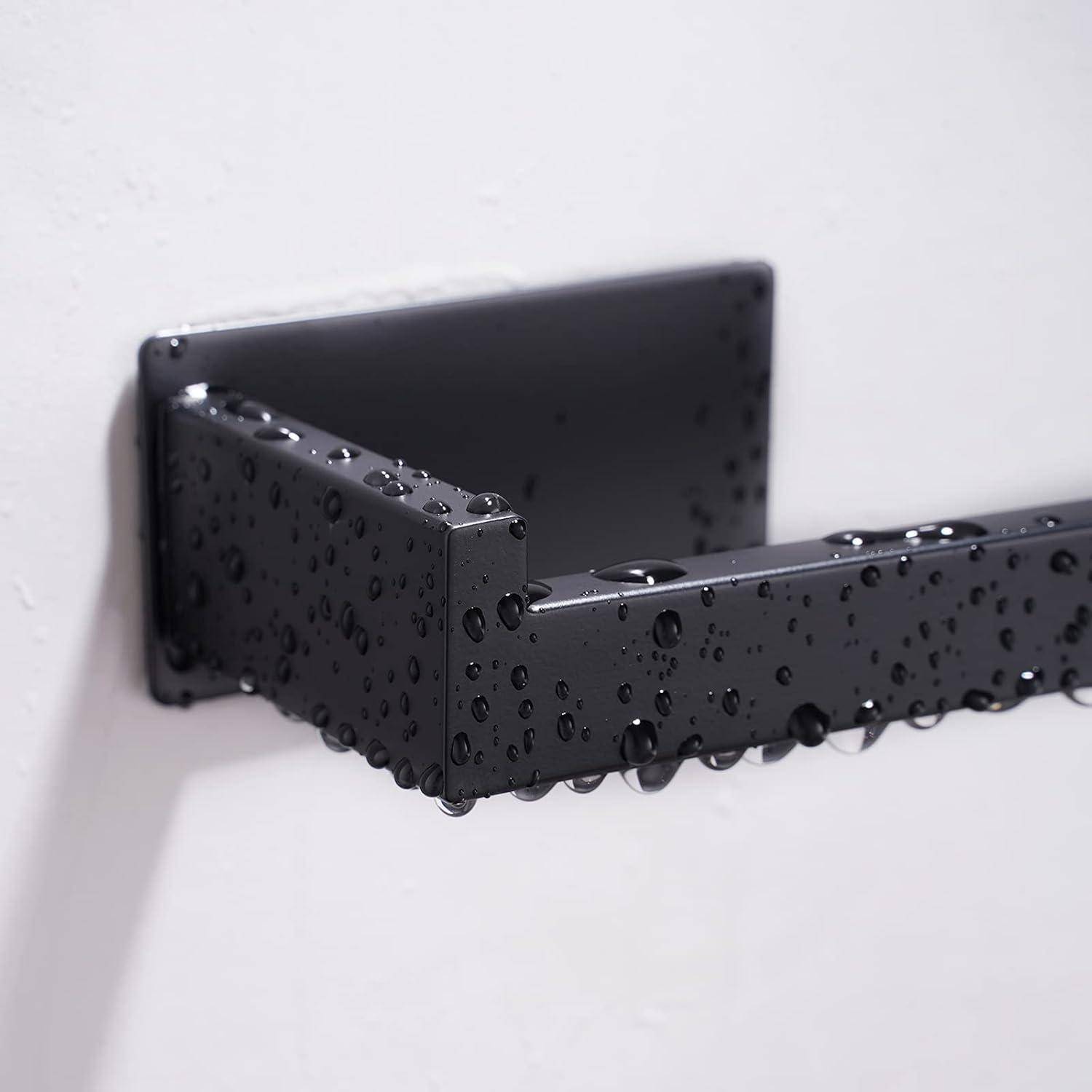 Schwarze Metalltürgriff mit Wassertropfen auf weißem Türhintergrund.