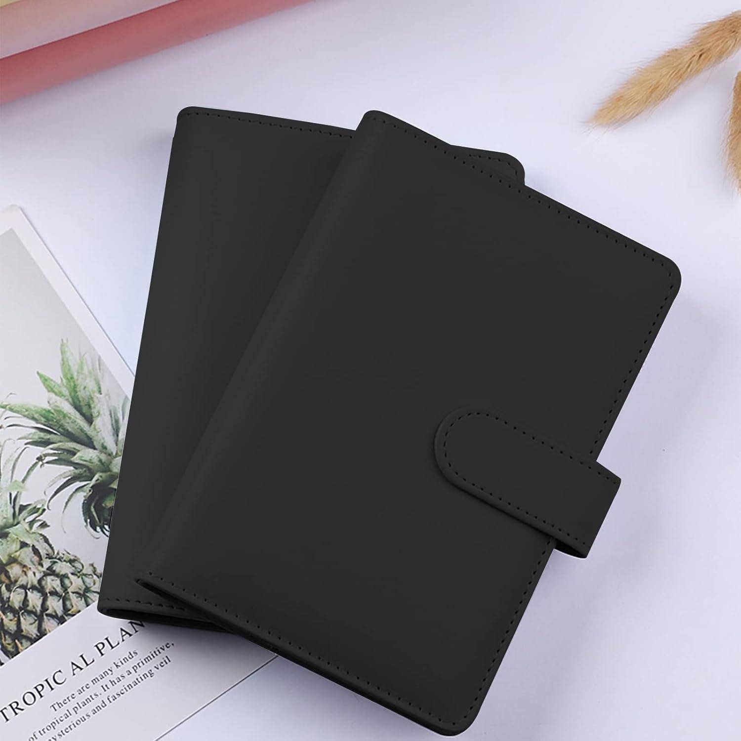 Schwarzer Lederbinder oder Notizbucheinband mit Riemen, gezeigt auf einer weißen Oberfläche neben einer Ananas-themed Karte.
