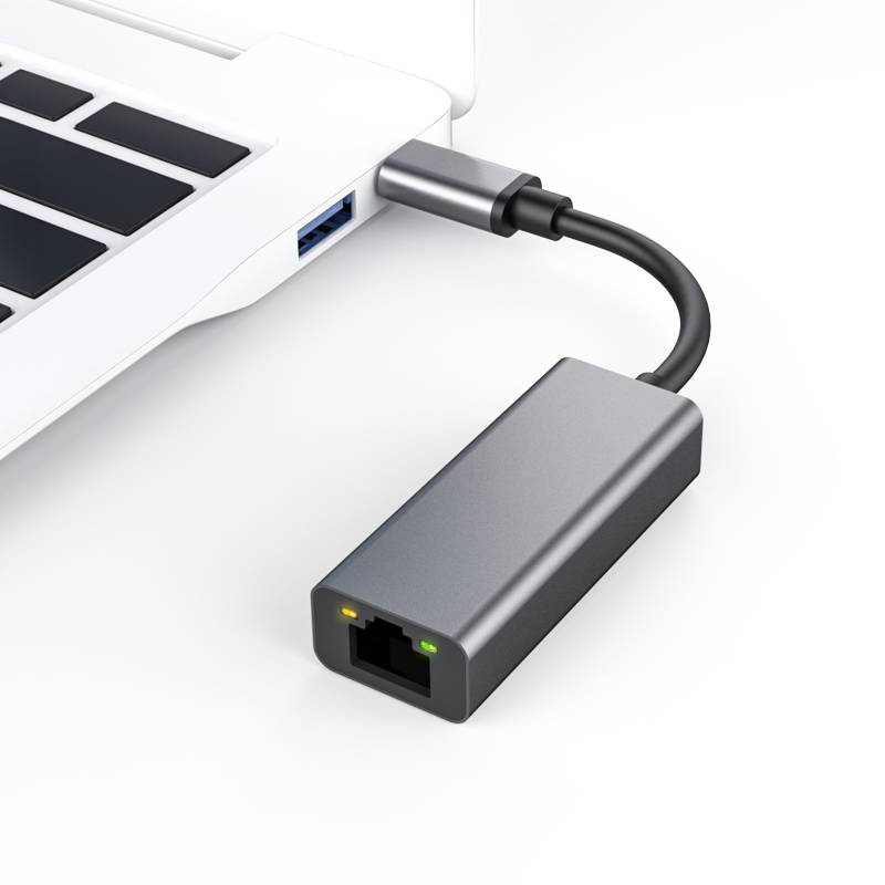 USB-C-auf-Ethernet-Adapter, der mit einem Laptop verbunden ist und einen Ethernet-Port mit Statusleuchten zeigt.