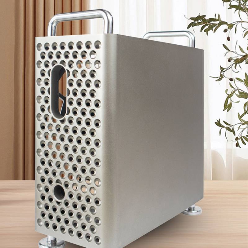 Kompakte Silbermetallbox mit Lochung und zwei Griffen auf einer Tischplatte, ähnlich einem tragbaren Koffer oder einer Kühleinheit.