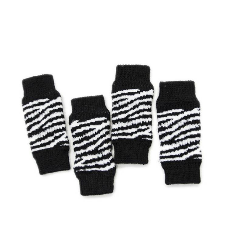 Vier schwarzweiß gestreifte Strickbeinwärmer auf weißem Hintergrund angeordnet.