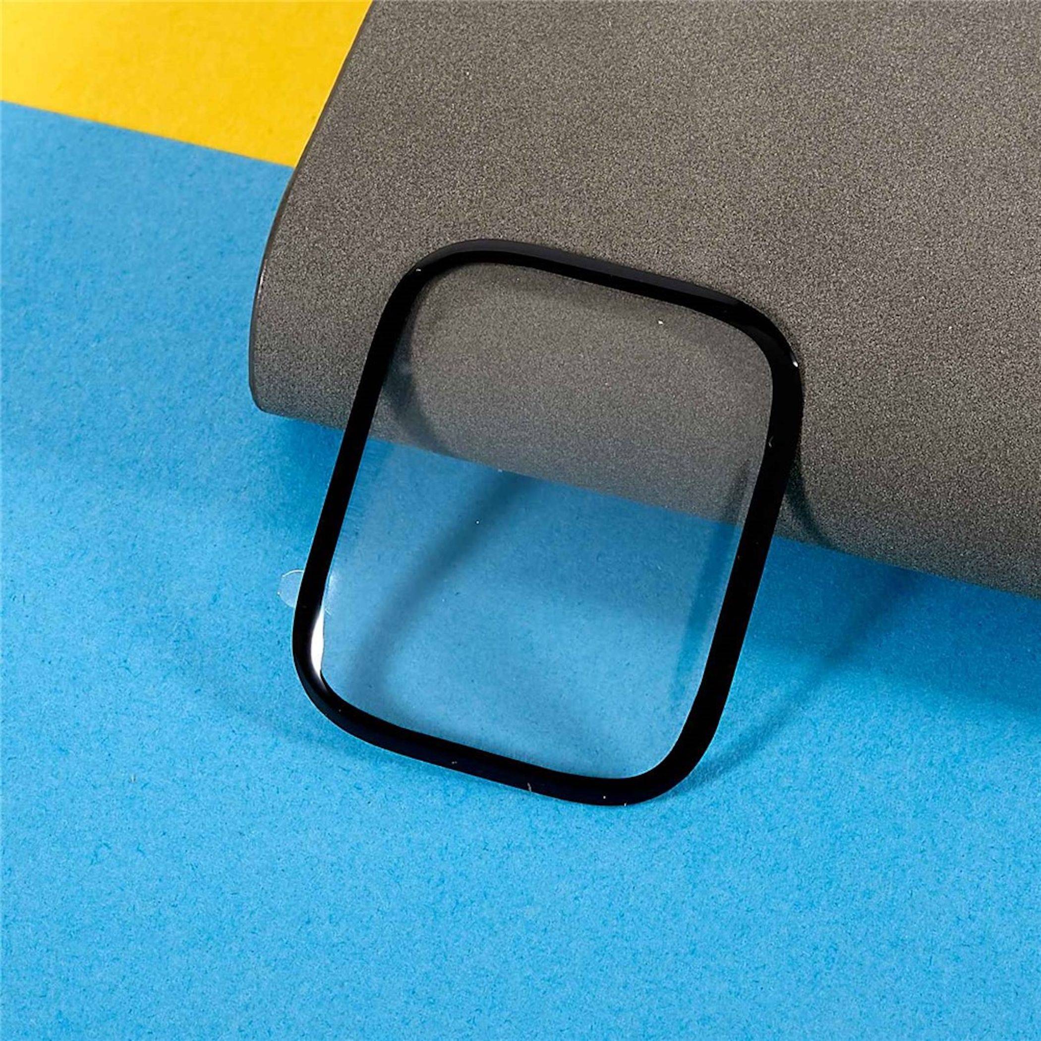 Schwarzer quadratischer Kameralinsenschutz für Telefone auf einem grauen Gerät vor blauem und gelbem Hintergrund.