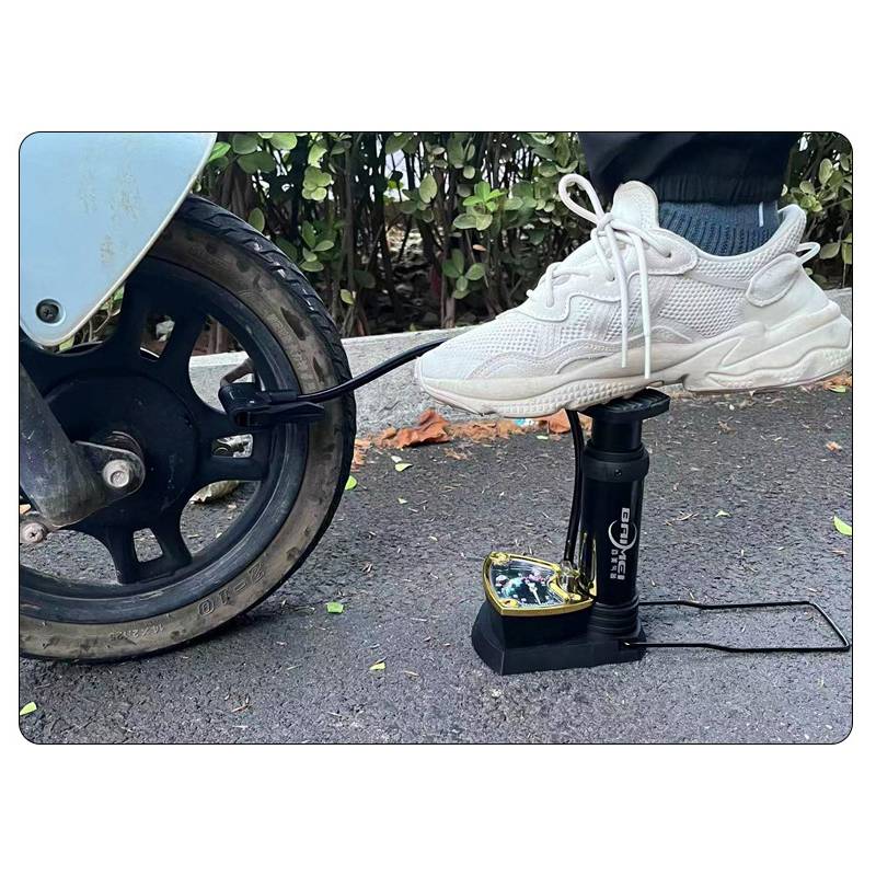 Ein Rollerring wird von einer tragbaren elektrischen Pumpe aufgepumpt, während ein weißer Sneaker auf den Pumpenkopf auf einer gepflasterten Straßenseite drückt.