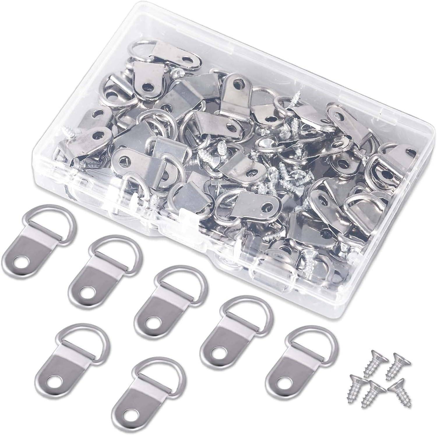 Klare Kunststoffbox gefüllt mit Metall-D-Ring-Hängern und Schrauben, mit mehreren Hängern, die darunter ausgelegt sind.