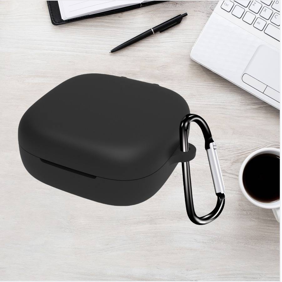 Schwarzes kabelloses Ohrhörer-Etui mit Karabiner an einem Schreibtisch neben einem Laptop, einem Stift und einer Kaffeetasse befestigt.