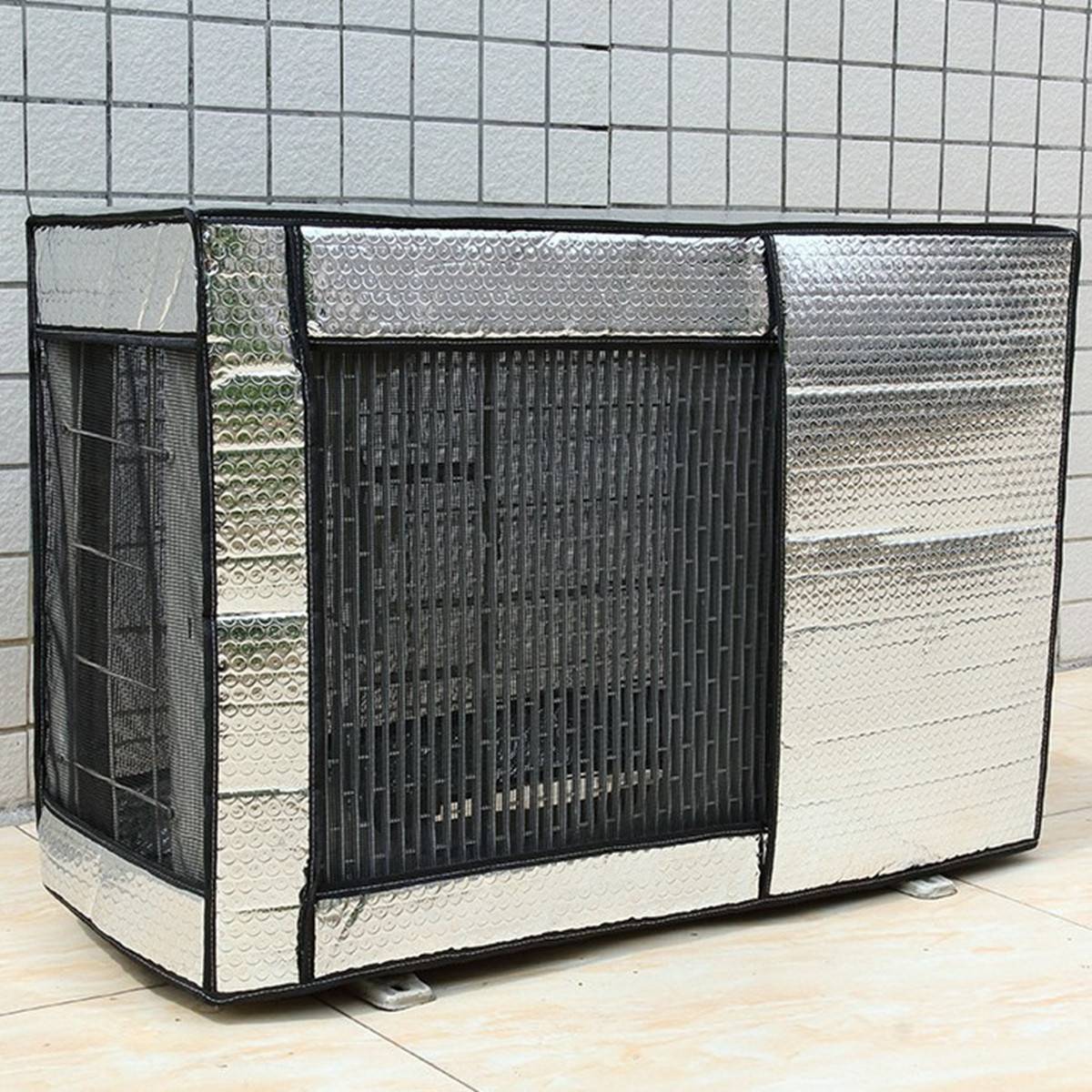 Metallische Maschenumhüllung und reflektierende Folieneinhausung für Ausrüstung, rechteckig und kastenförmig, auf einem Fliesenboden gegen eine Gittermusterwand stehend.