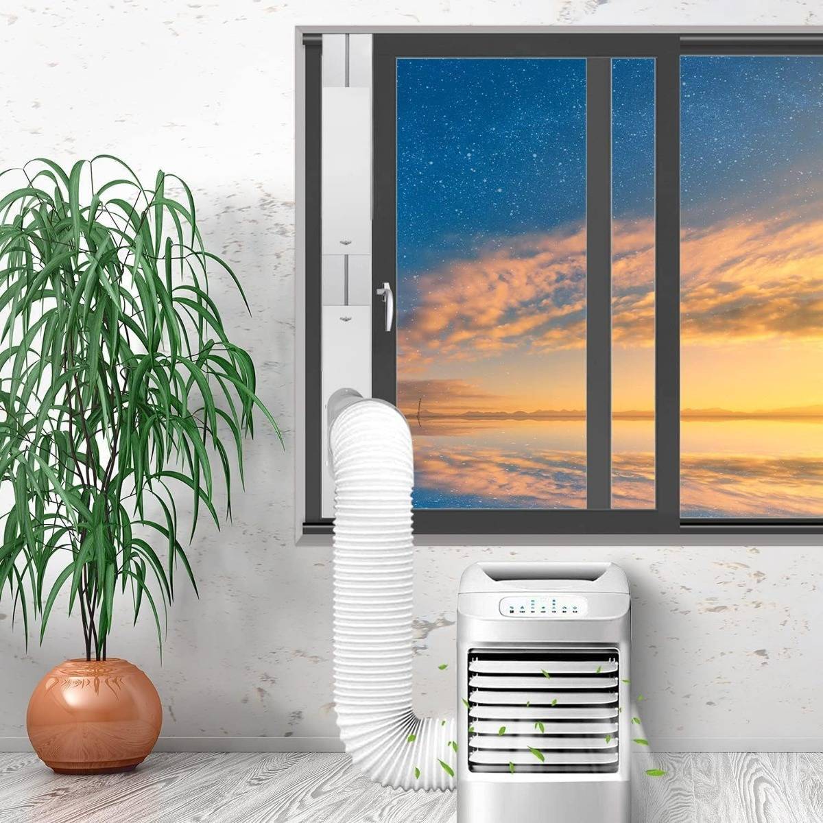 Tragbarer Luftkühler mit Schlauch neben einer Topfpflanze an einem Fenster, das einen Sonnenuntergangshimmel zeigt und indoor Kühlung und Belüftung andeutet.