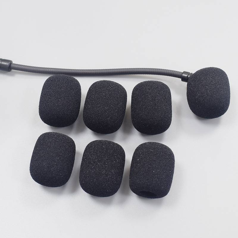 Sechs schwarze Schaumstoff-Windschutzscheiben für Mikrofone, wobei eine an einem flexiblen Mikrofonarm befestigt ist, angeordnet auf weißem Hintergrund.