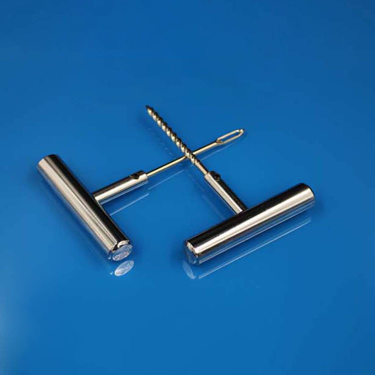 Edelstahl-T-Griff-Handbohrmaschine mit Schneckenbohrer auf einer blauen Oberfläche.