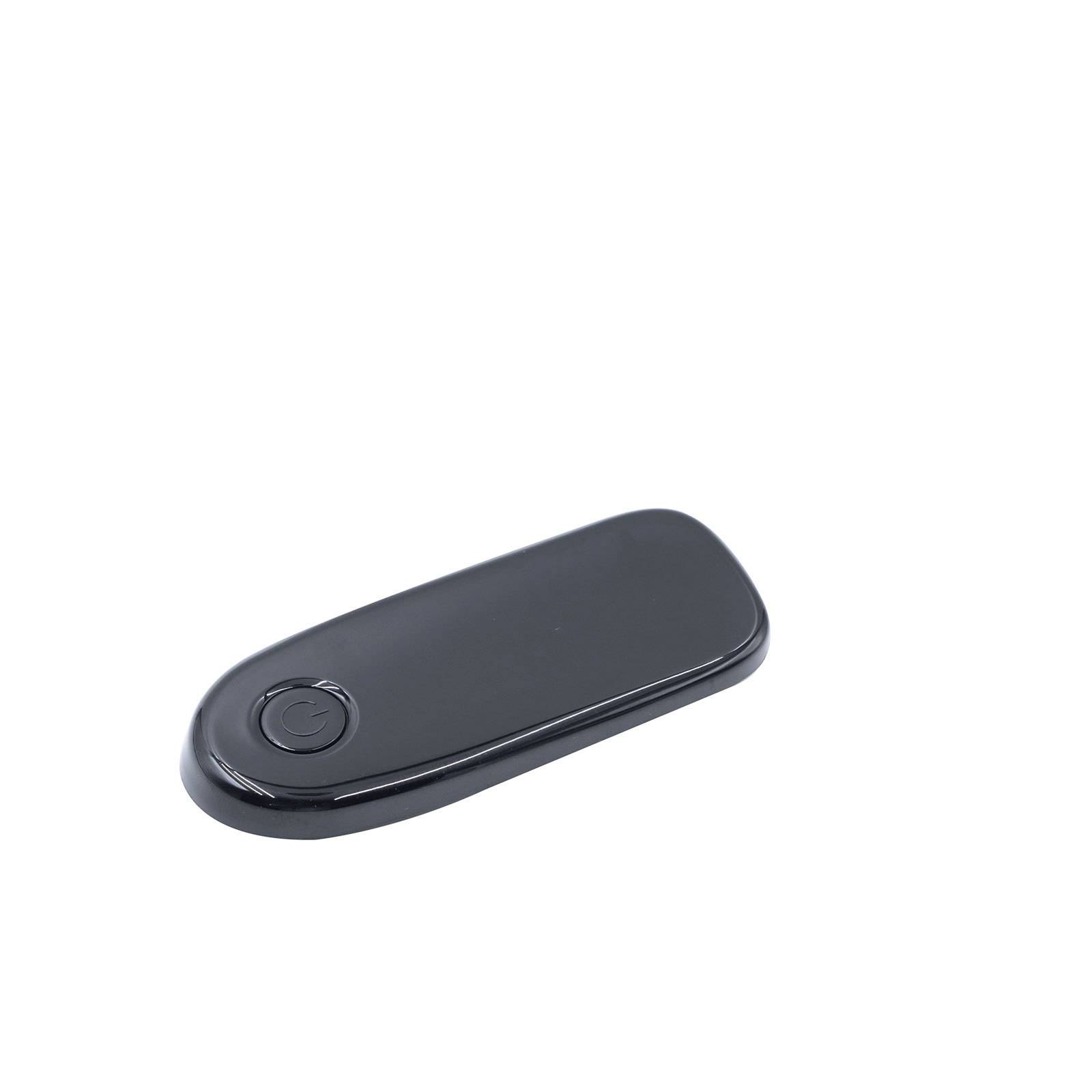 Schwarze ovale Fernbedienung oder kabelloser Clicker auf weißem Hintergrund, mit einem einzelnen kreisförmigen Knopf an einem Ende.