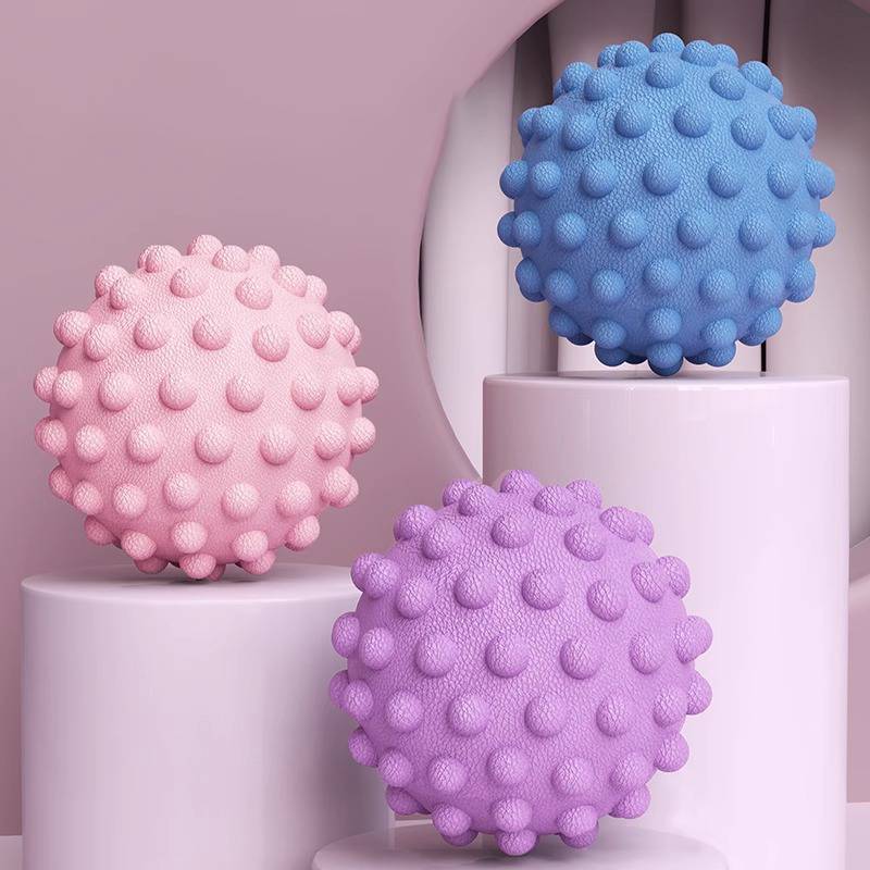 Drei pastellfarbene stachelige Kugeln – rosa, blau und violett – auf weißen Sockeln vor einem sanft rosa Hintergrund präsentiert.