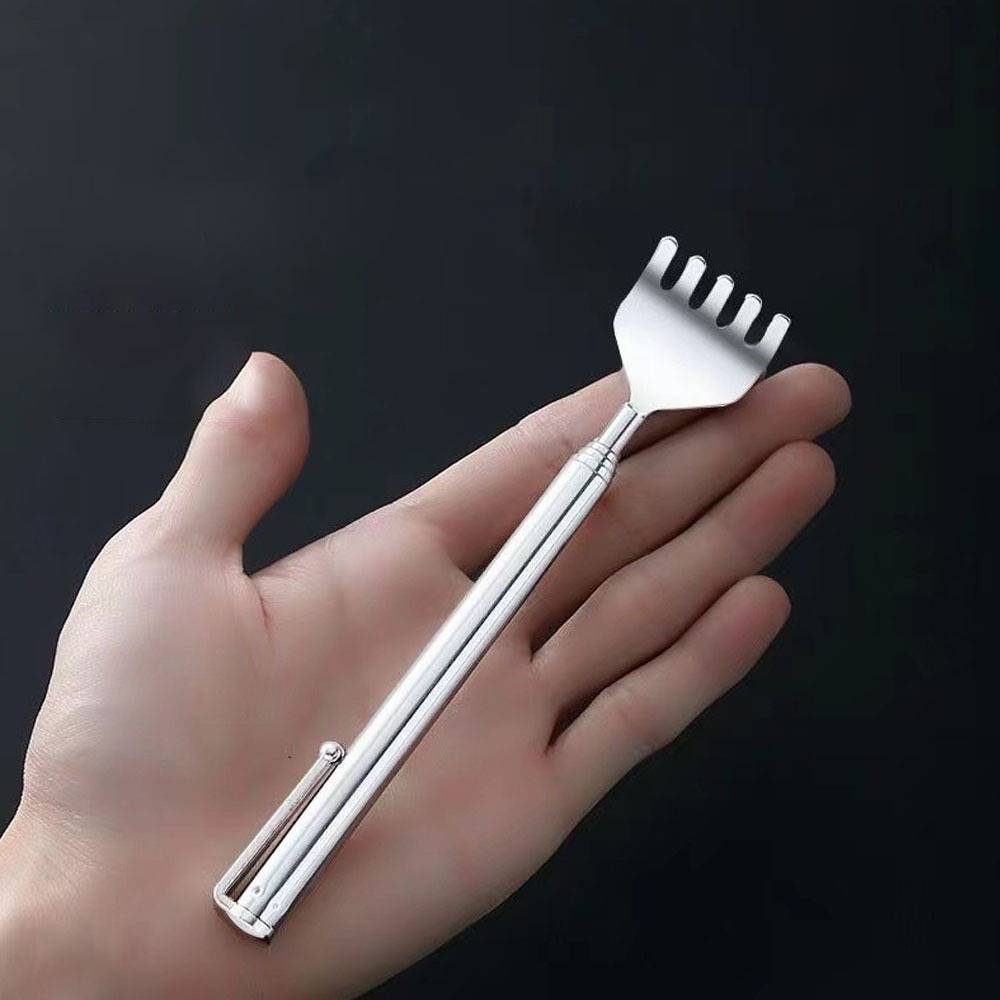 Eine Hand, die einen silbernen Metall-Rückenkratzer mit gegabeltem Kopf vor einem dunklen Hintergrund hält.