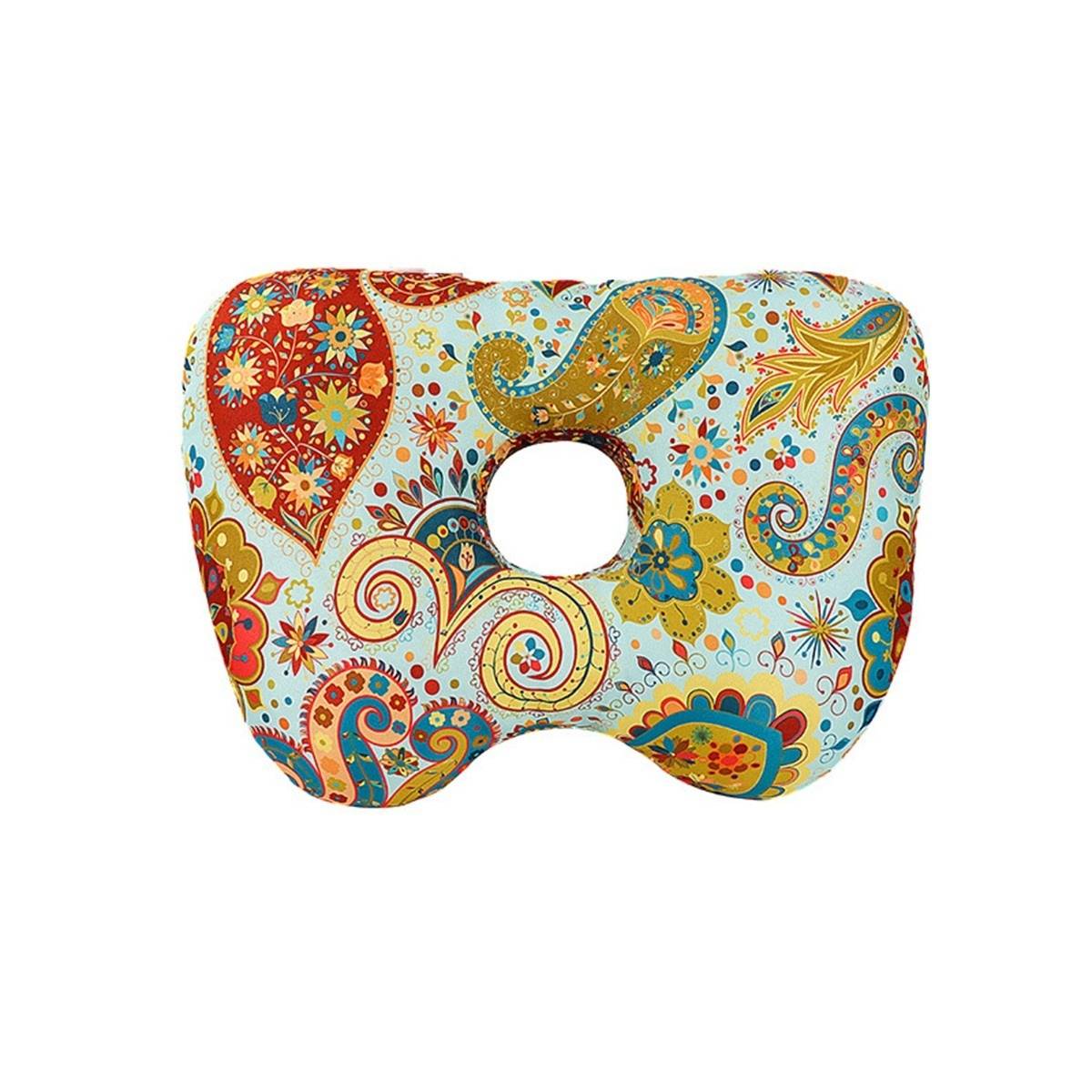 Bunte gemusterte donutförmige Sitzkissen mit einem Loch in der Mitte, gezeigt auf weißem Hintergrund.