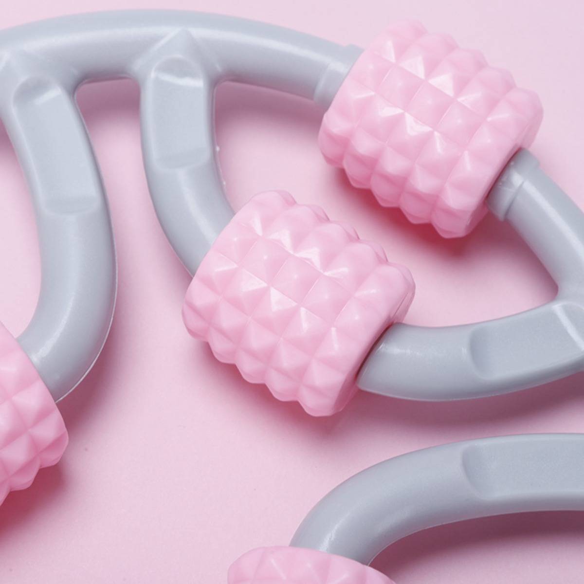 Nahaufnahme von rosa und grauen ineinandergreifenden Spielzeugkettengliedern auf rosa Hintergrund.