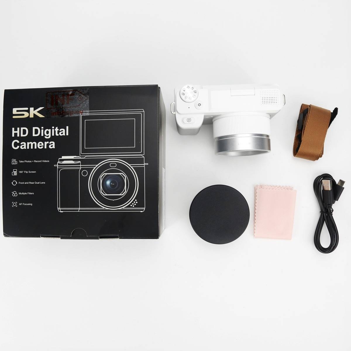 Weiße 5K HD Digitalkamera mit Zubehör bestehend aus Originalverpackung, Objektivdeckel, Handgelenkschlaufe, Reinigungstuch und USB-Kabel auf weißem Hintergrund.