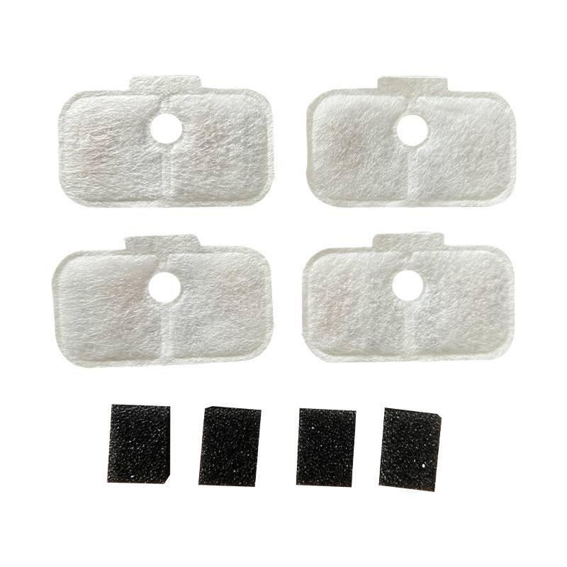 Vier weiße Klebepads mit mittigen Löchern und vier kleine schwarze Schaumstoffstücke darunter auf schlichtom Hintergrund angeordnet.