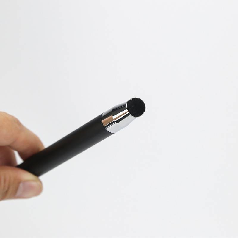 Hand, die einen schwarzen Stift mit einer abgerundeten Schaumstoffspitze gegen einen einfachen weißen Hintergrund hält.